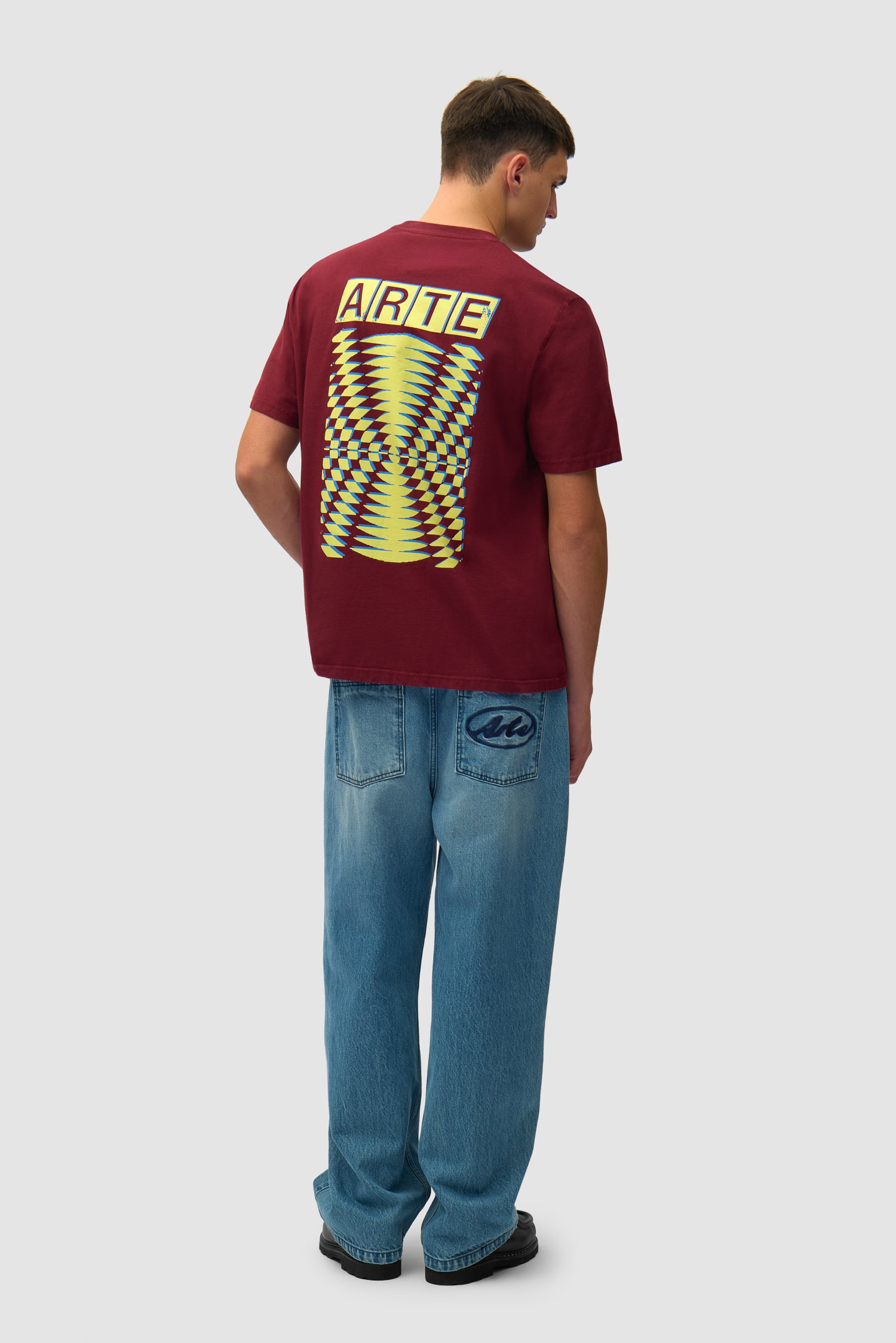 T-shirt à dos imprimé abstrait couleur bordeaux porté par un mannequin, vue de profil en pied