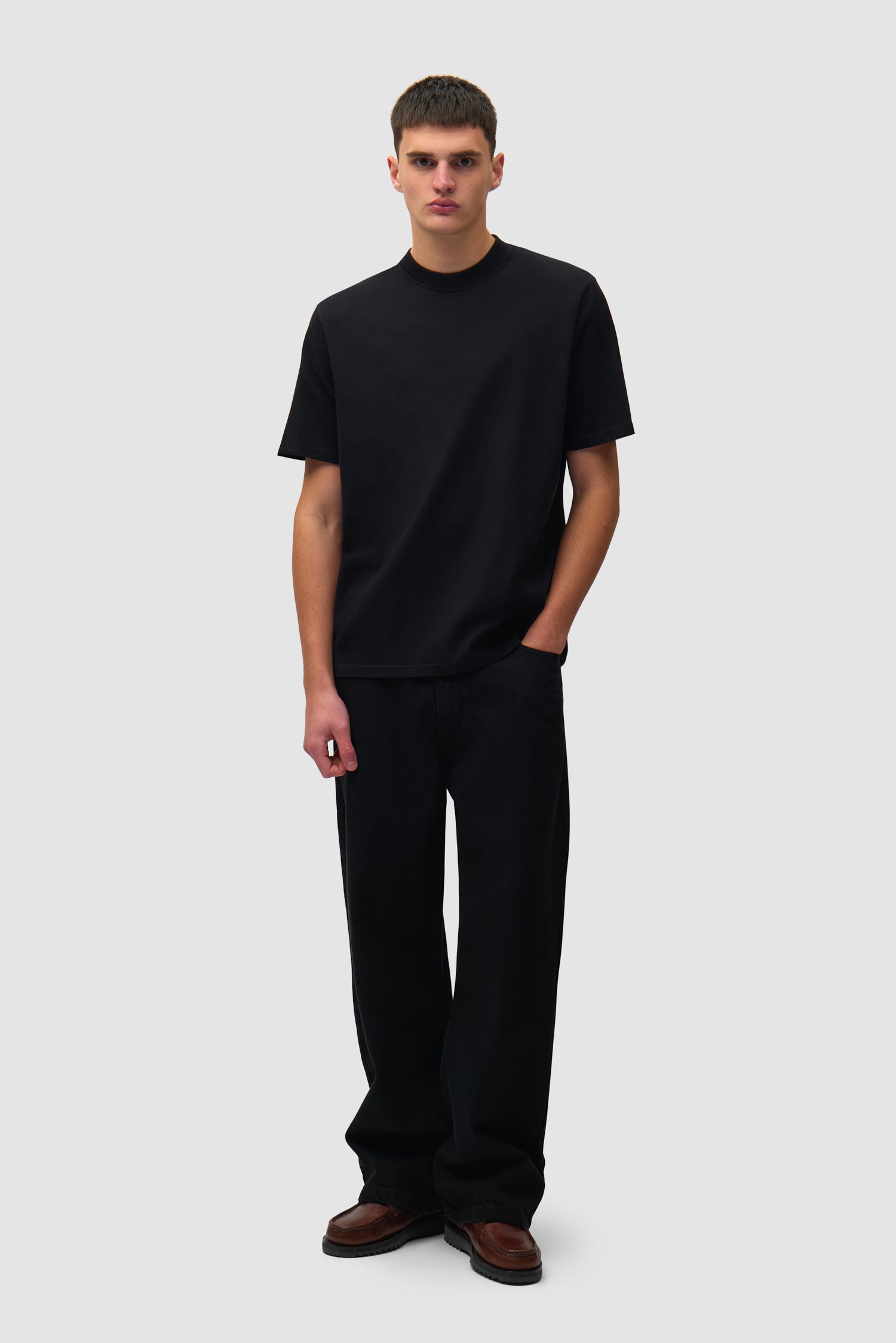 T-shirt noir à grand logo dans le dos porté par un mannequin, vue de face en pied