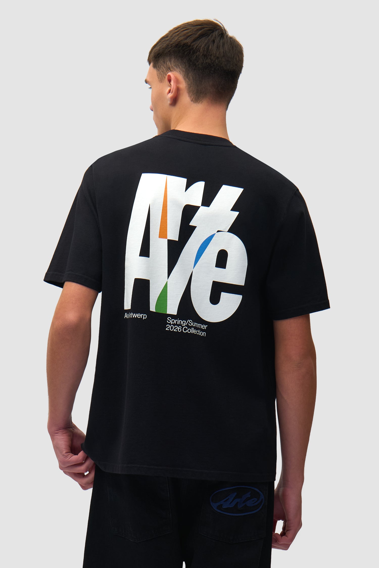 T-shirt noir à grand logo dans le dos porté par un mannequin, vue de dos à mi-corps