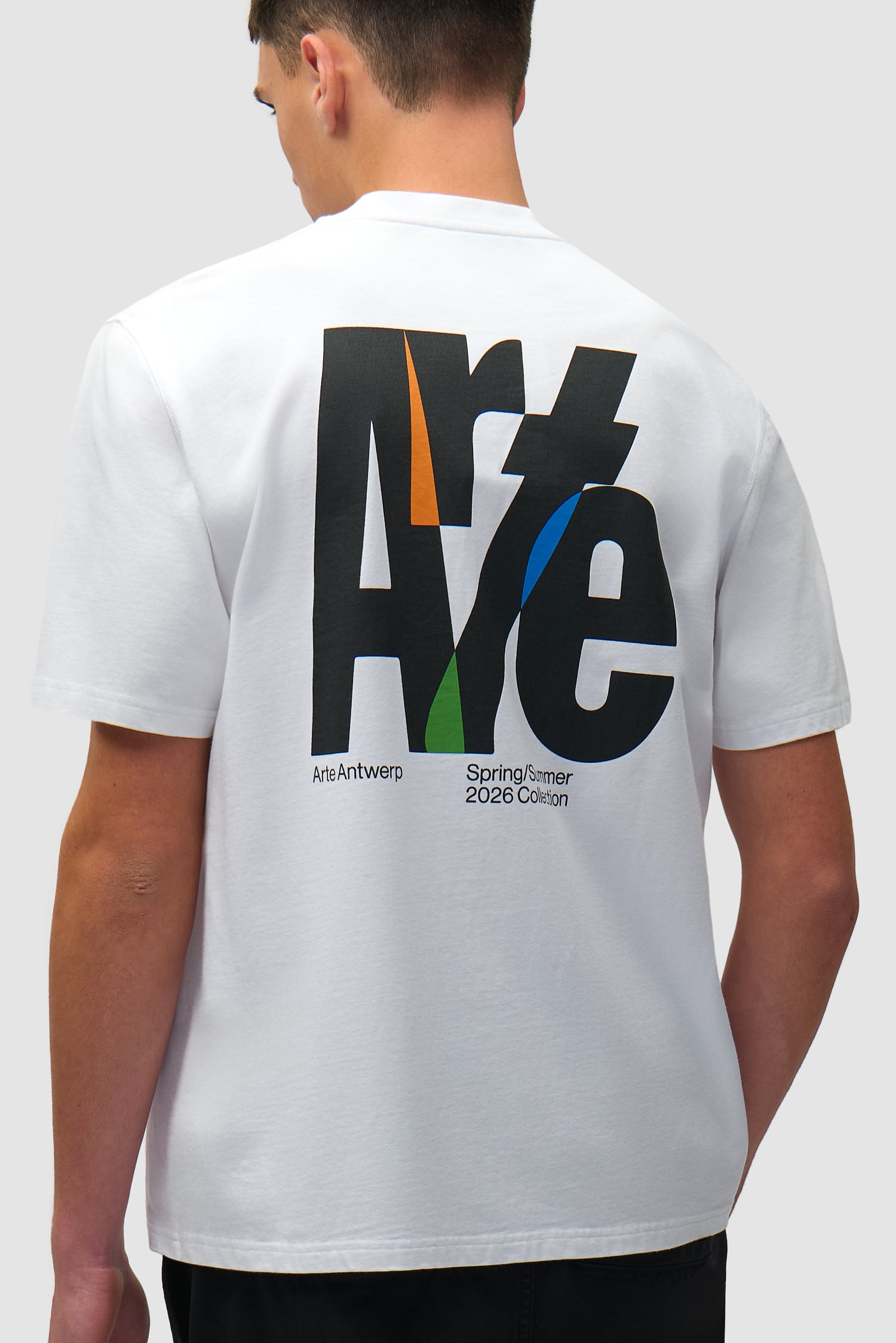 T-shirt blanc à grand logo dans le dos porté par un mannequin, vue de profil à mi-corps