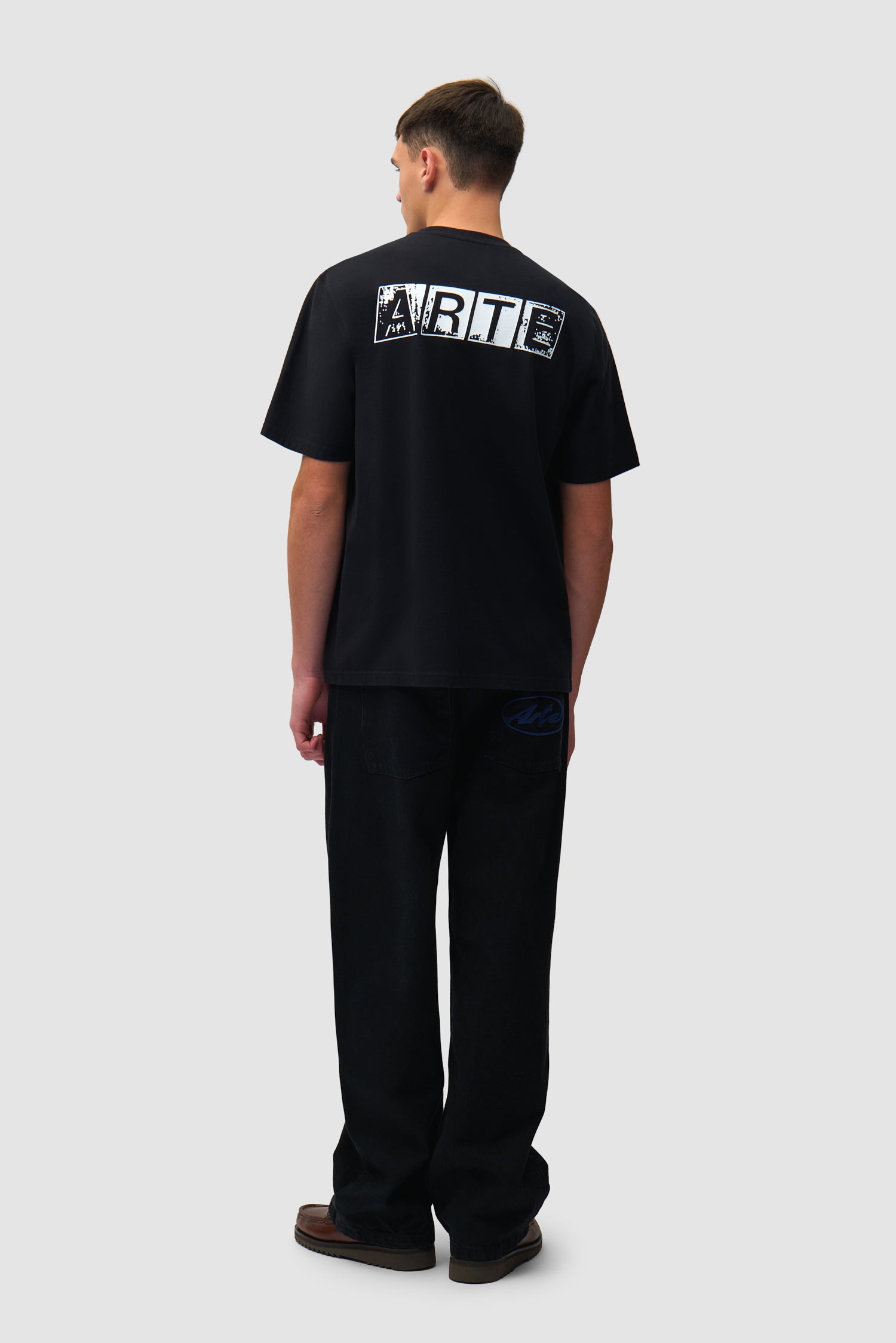 T-shirt noir délavé avec imprimé dans le dos porté par un mannequin, vue de profil en pied