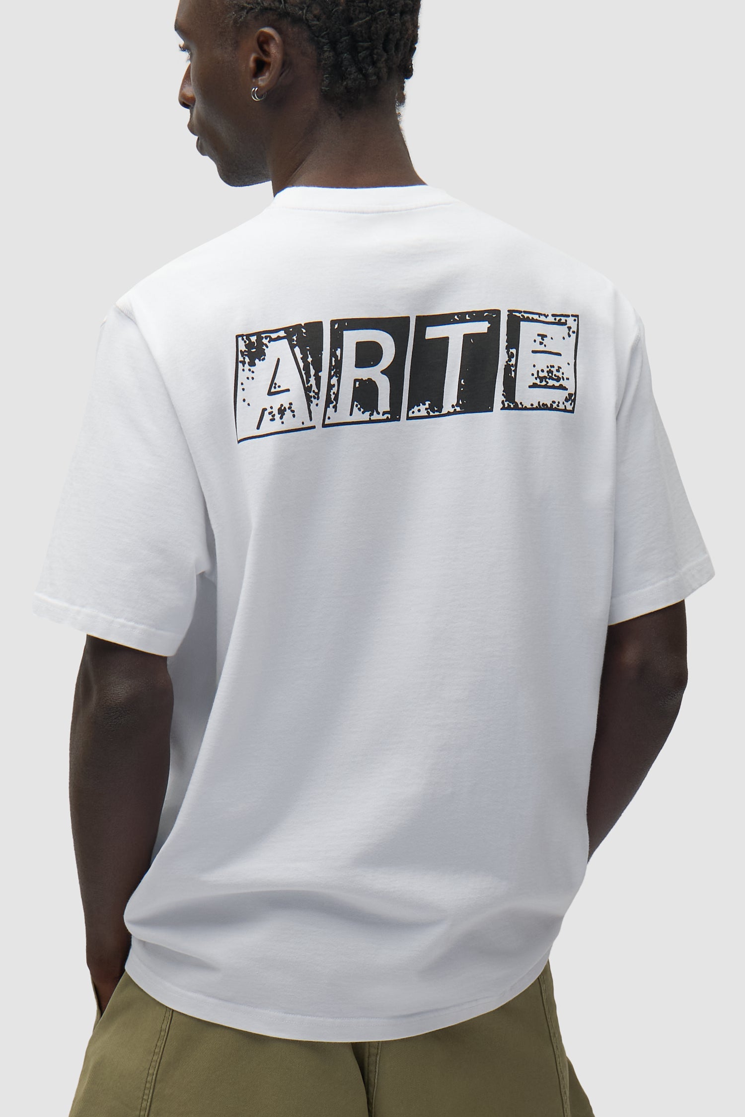 T-shirt blanc délavé avec imprimé dans le dos porté par un mannequin, vue de profil à mi-corps