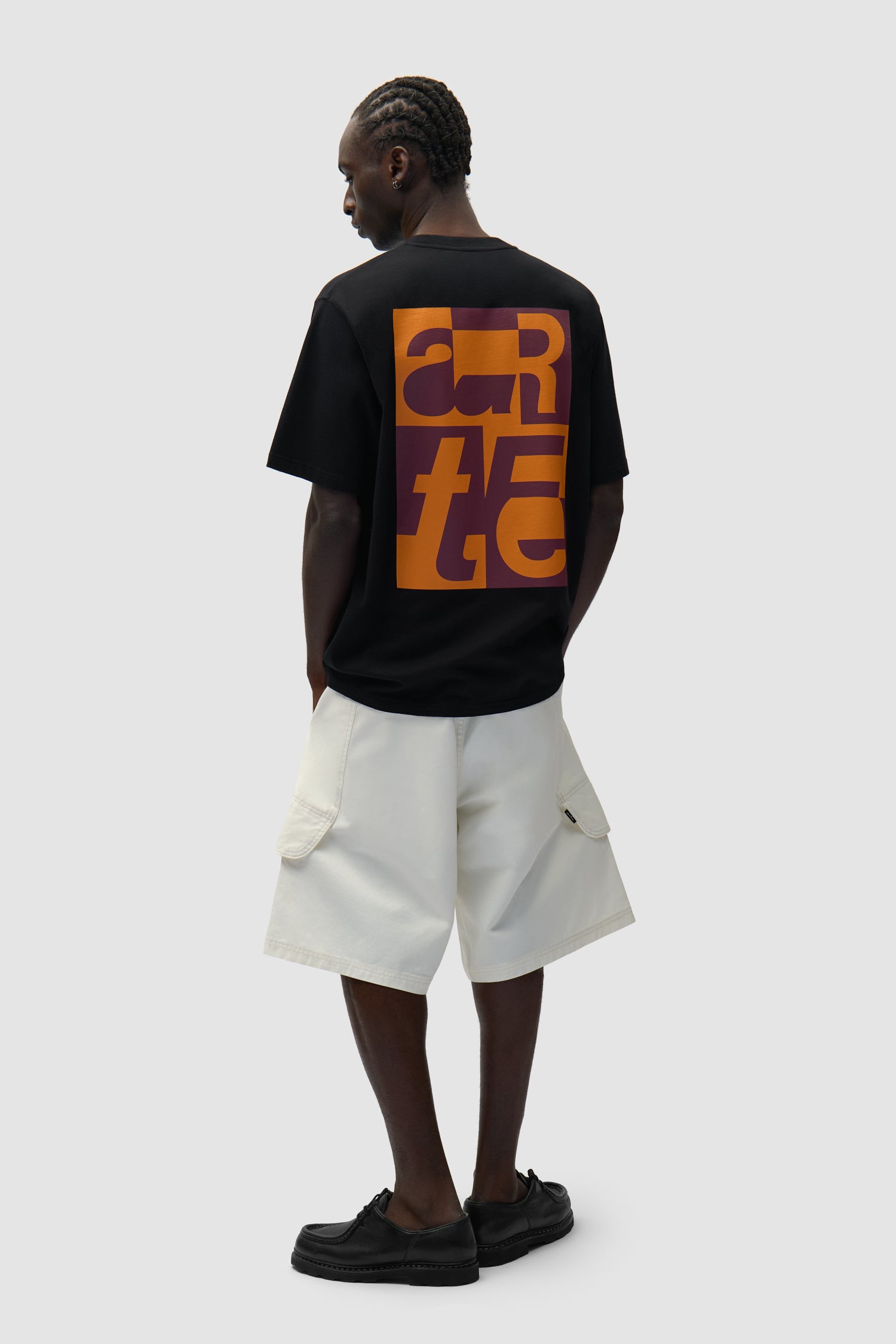 T-shirt graphique noir porté par un mannequin, vue de profil en pied