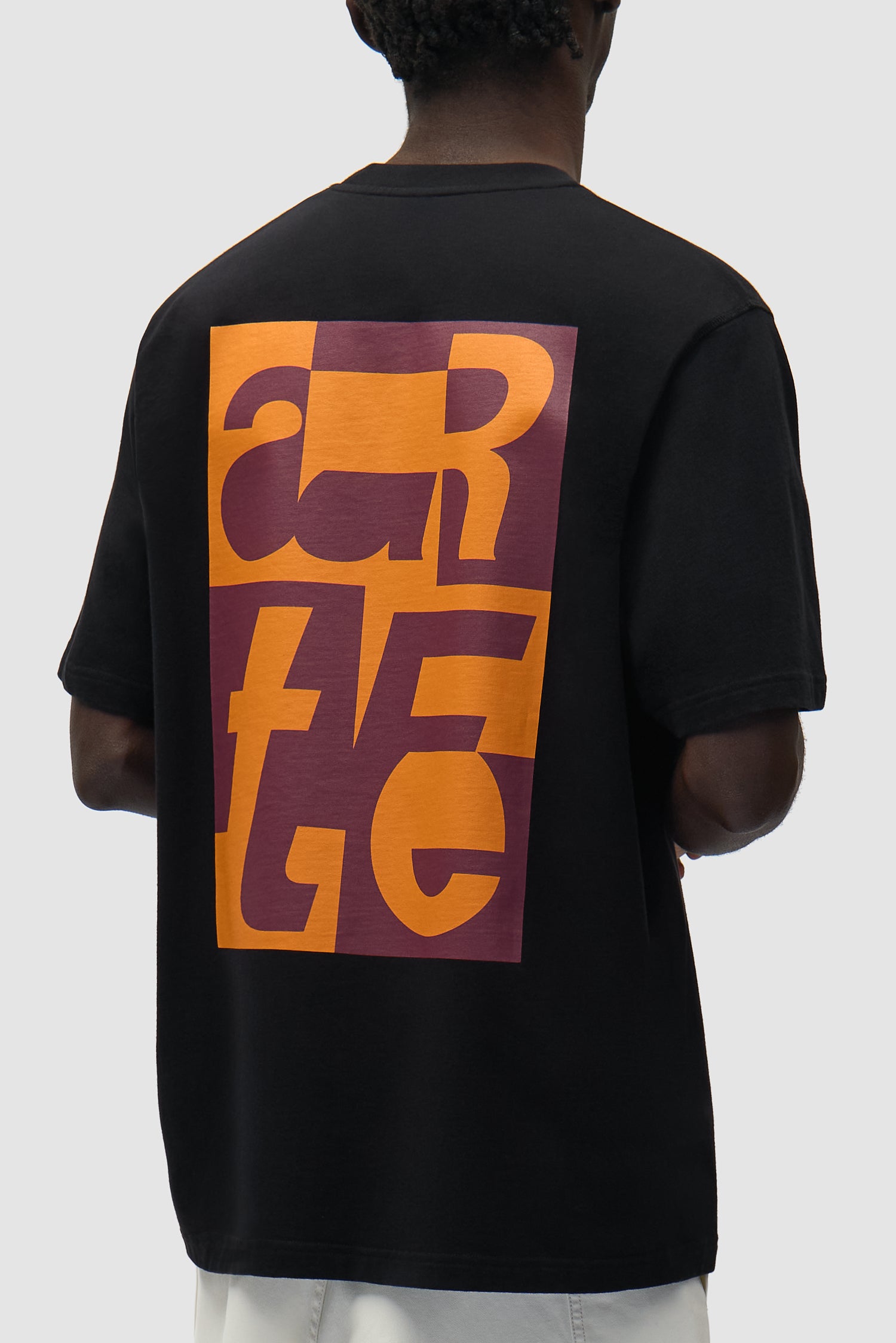 T-shirt graphique noir porté par un mannequin, vue de profil à mi-corps