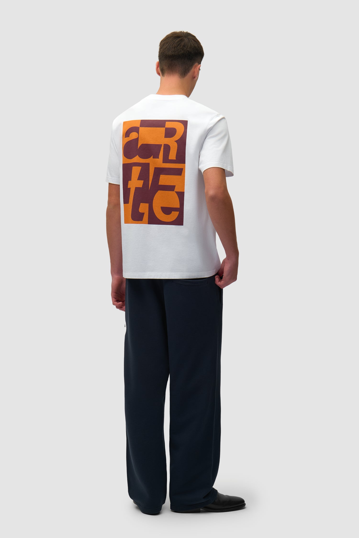 T-shirt graphique blanc porté par un mannequin, vue de profil en pied