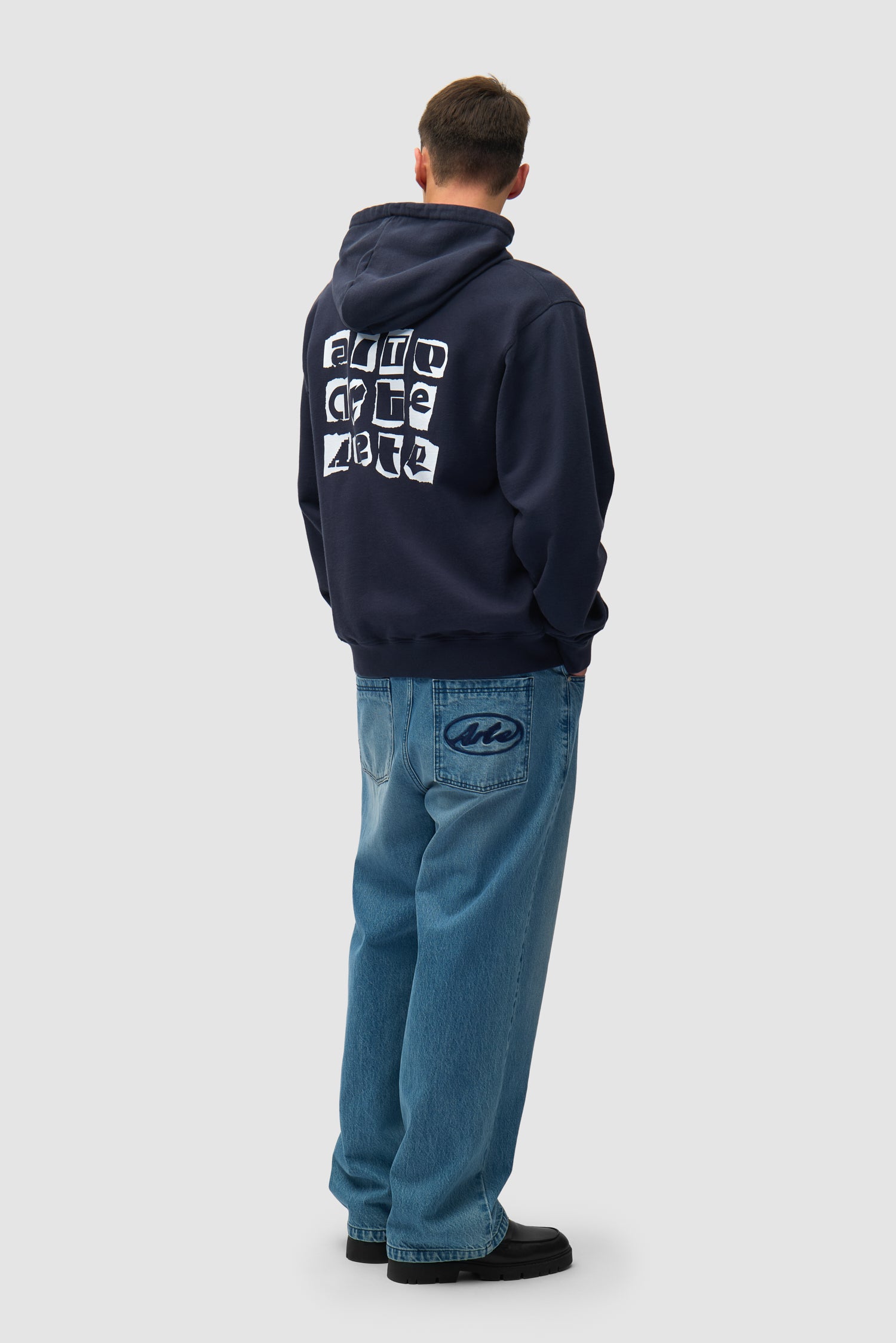 Sweat à capuche Multi Back Logo en bleu marine porté par un mannequin, vue de profil en pied