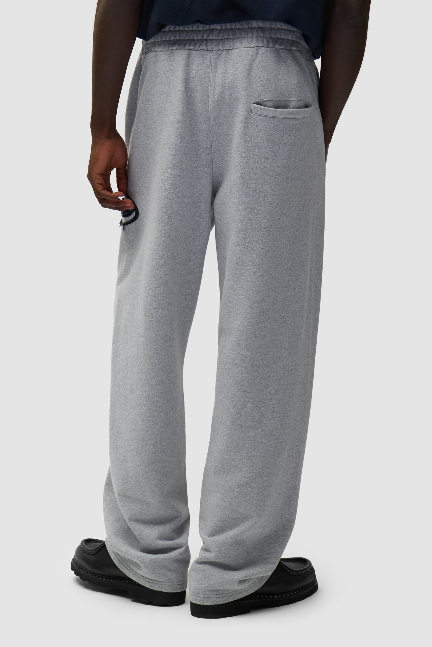 Circle Patch Logo Sweatpants in Grey worn by a model, half-body back view