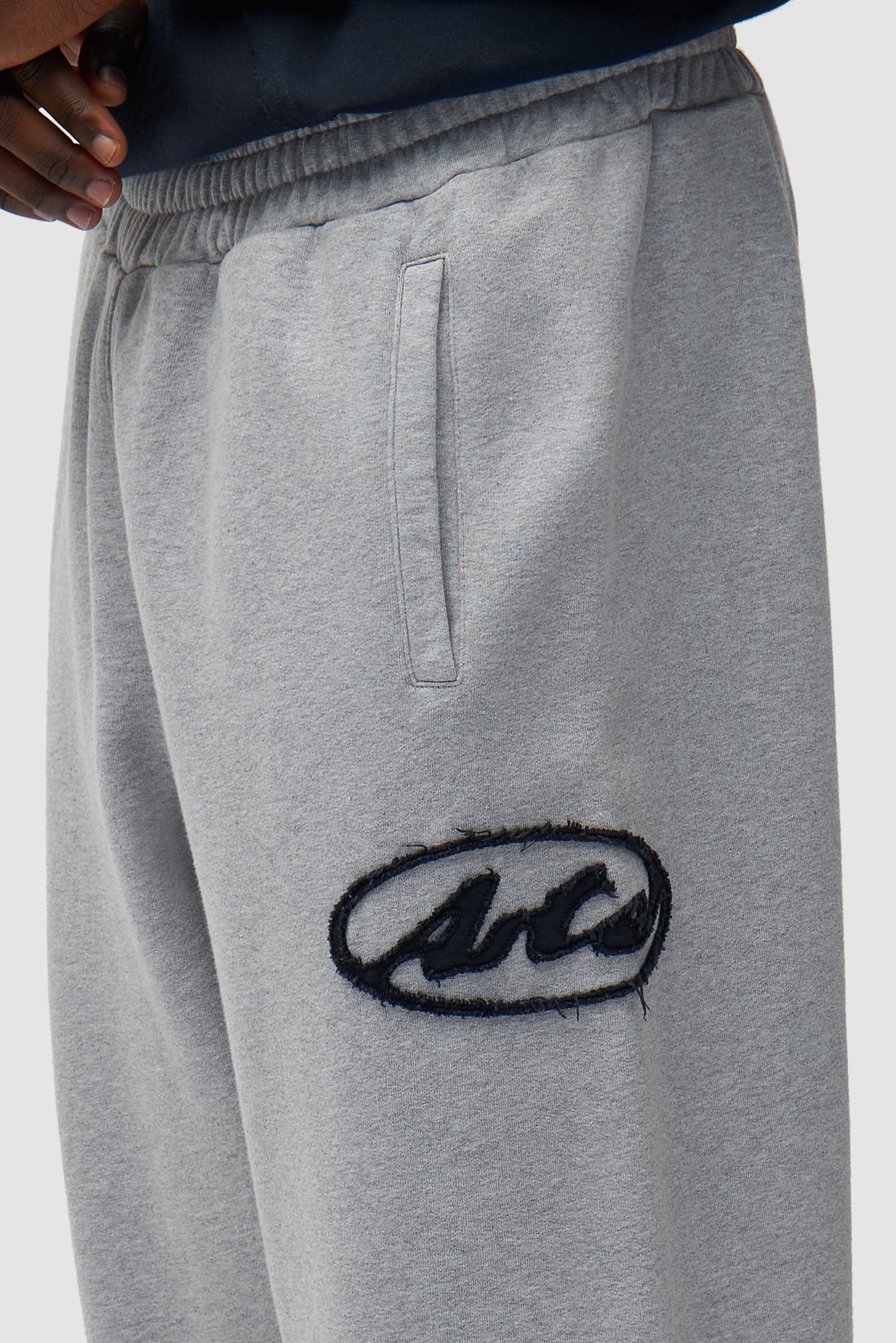 Detail view of Circle Patch Logo Sweatpants in Grey, showing front logo