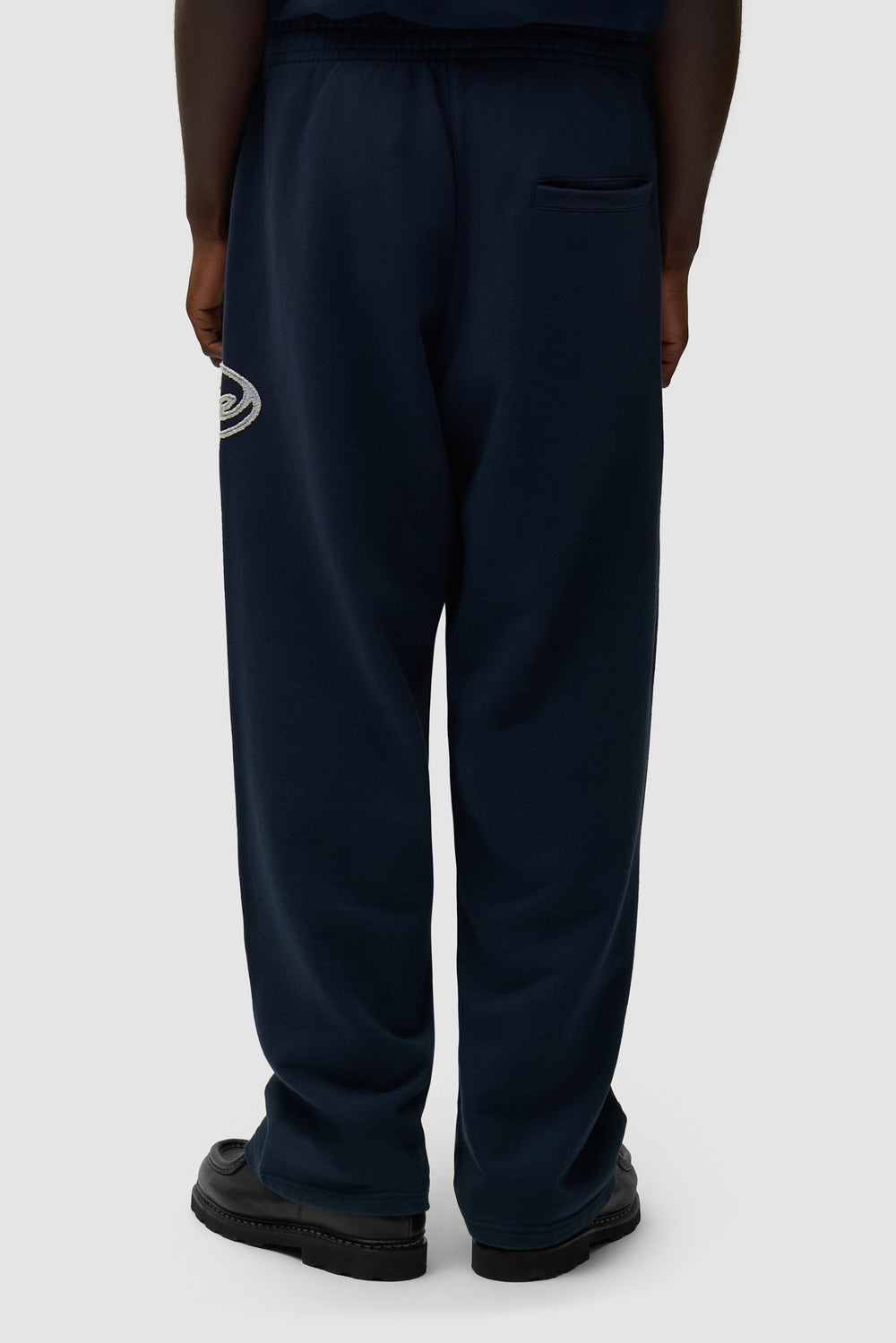 Circle Patch Logo Sweatpants in Navy worn by a model, half-body back view