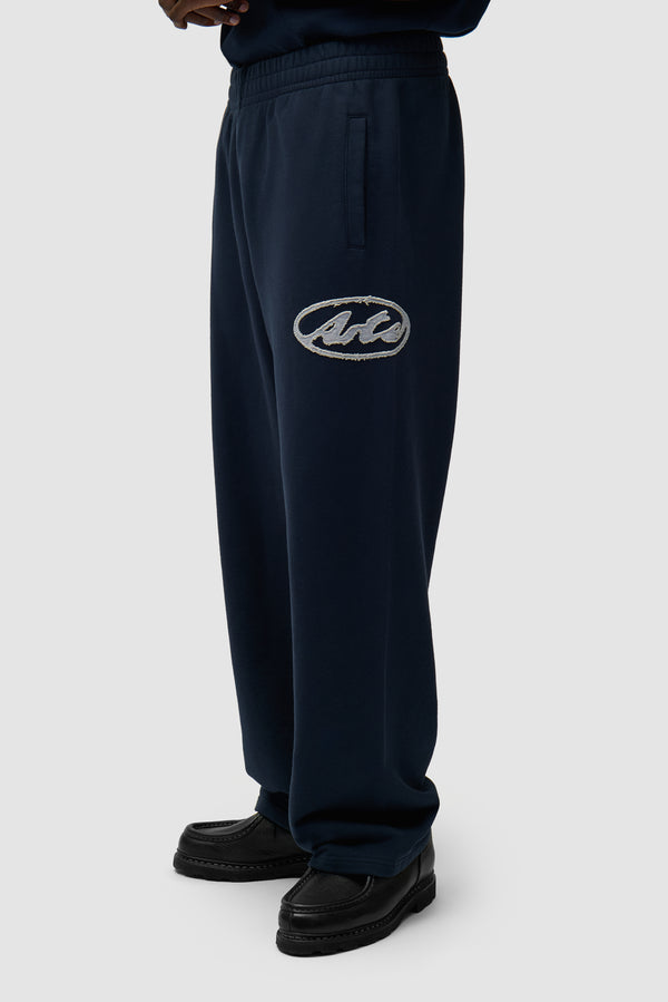 Circle Patch Logo Sweatpants in Navy worn by a model, half-body side view