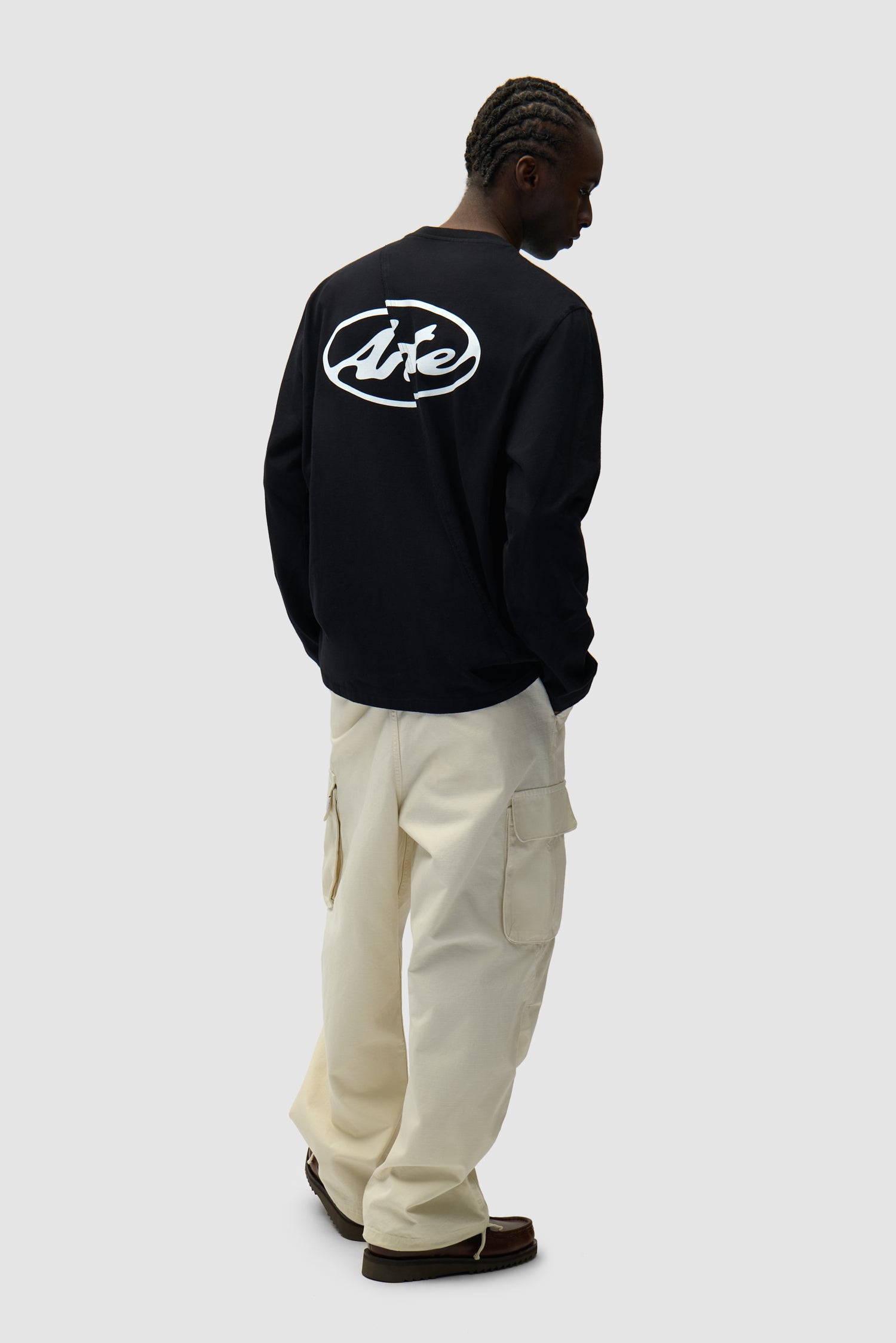 Back Circle Logo Longsleeve in Black worn by a model, full-body side view