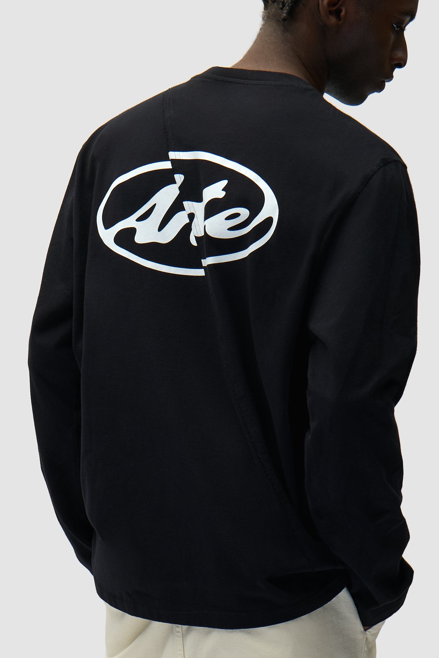 Back Circle Logo Longsleeve in Black worn by a model, half-body detailed view