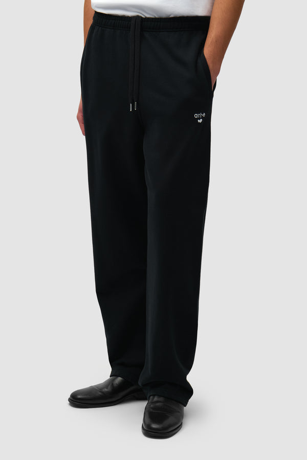 Heart Logo Sweatpants in Black worn by a model, half-body side view