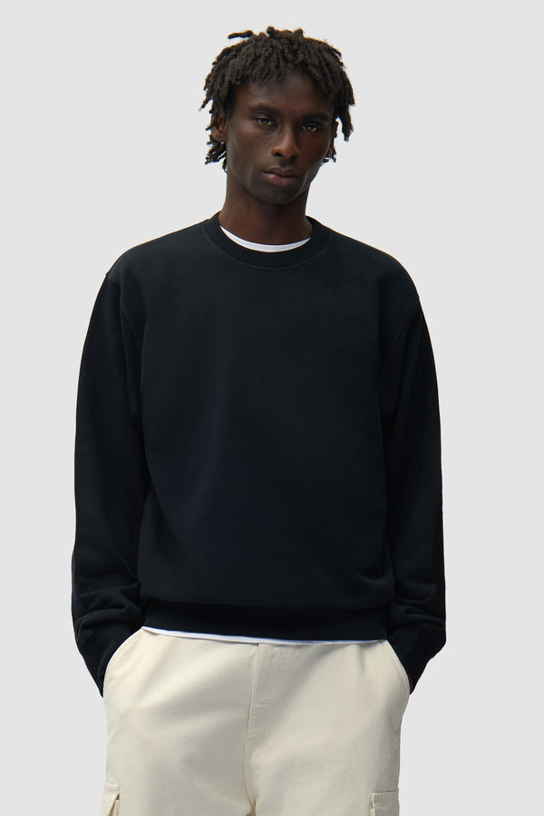 Back SS26 Crewneck in Black worn by a model, half-body front view