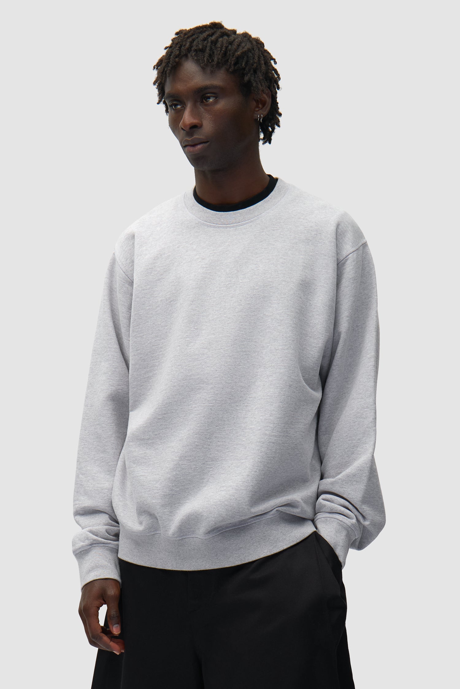 Dos SS26 Crewneck en gris porté par un mannequin, vue de face en demi-corps