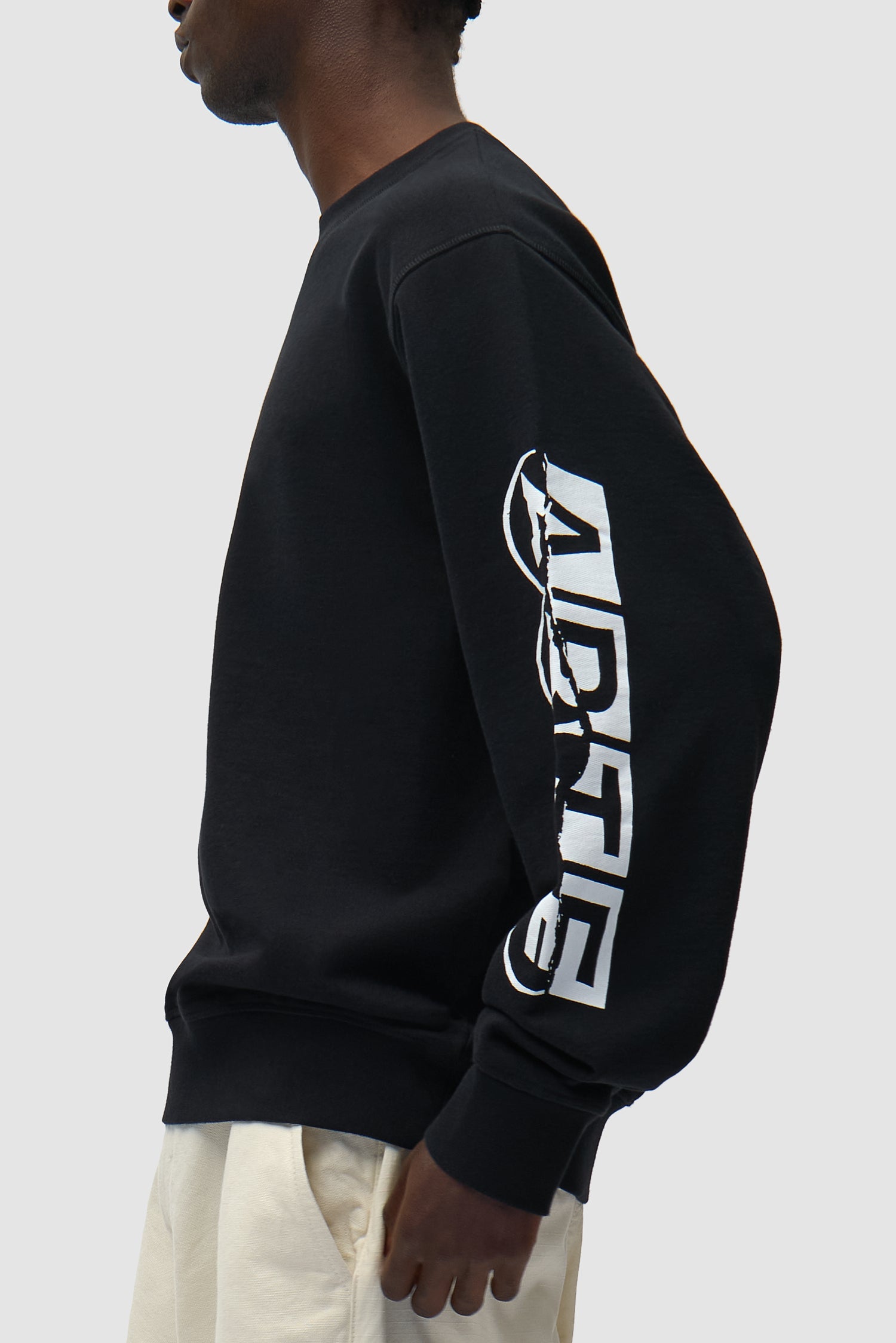 Vue détaillée du t-shirt à manches courtes et col rond imprimé noir, montrant le logo sur la manche.