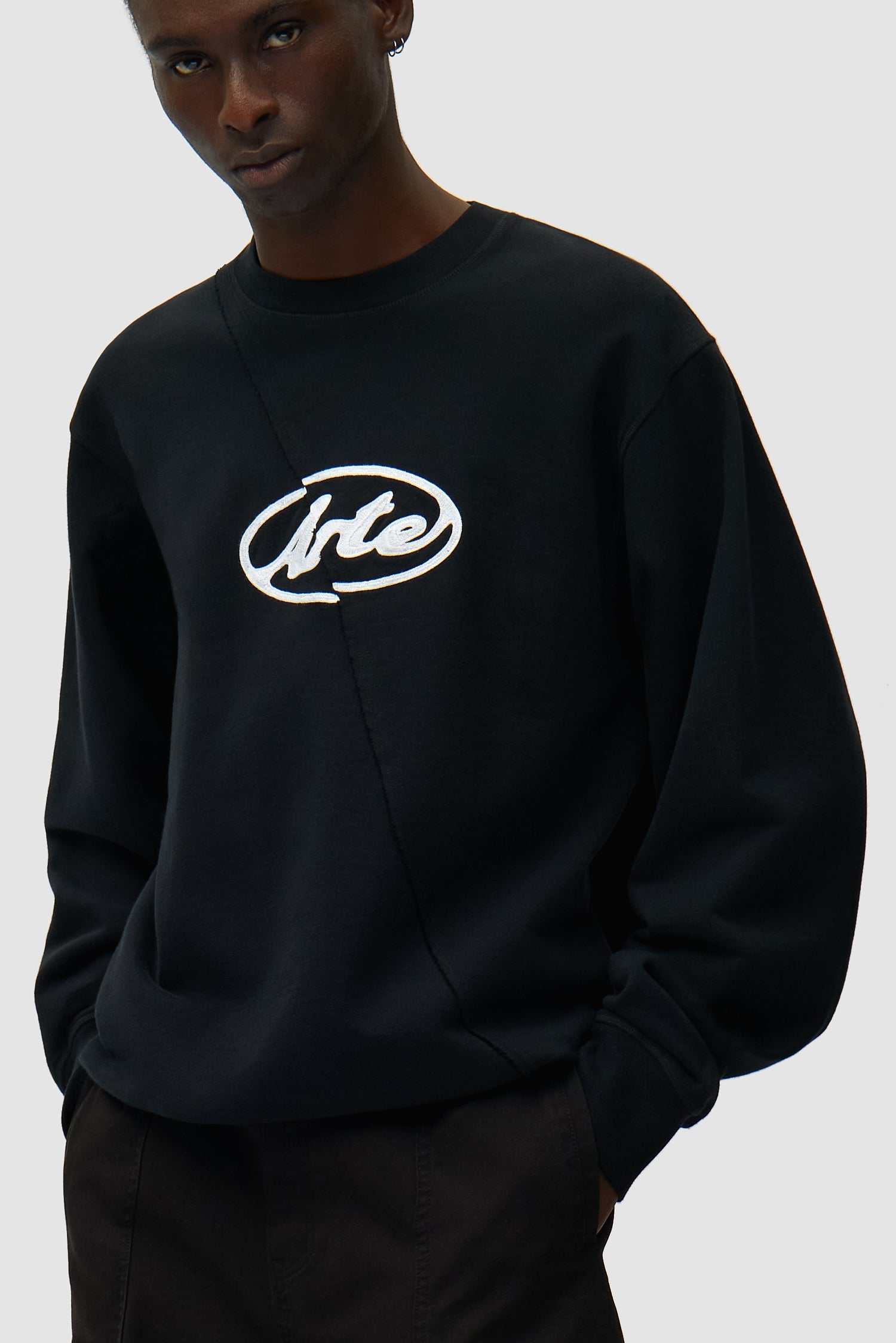 Circle Logo Embroidery Sweater in Black worn by a model, half-body detailed view