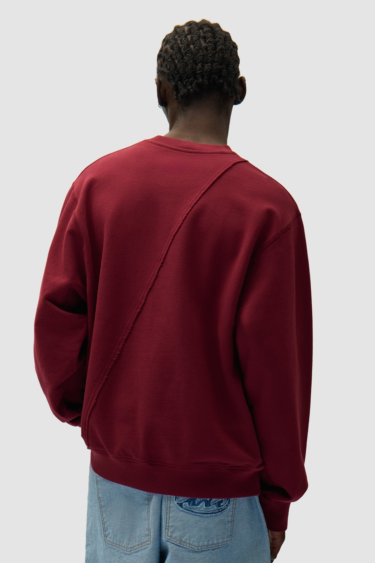 Circle Logo Embroidery Sweater in Bordeaux worn by a model, full-body side view