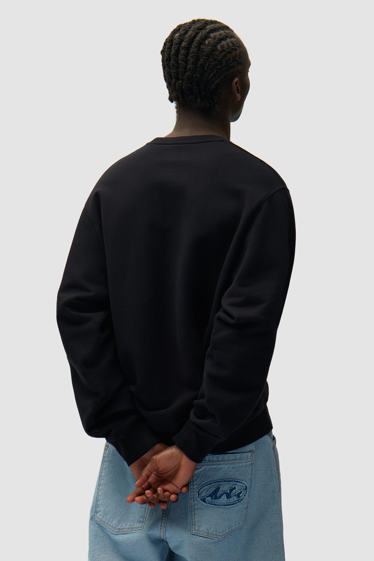 Address Crewneck in Black worn by a model, half-body back view
