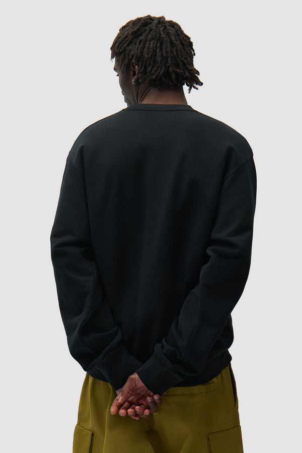 Multi Logo Crewneck in Black worn by a model, half-body back view