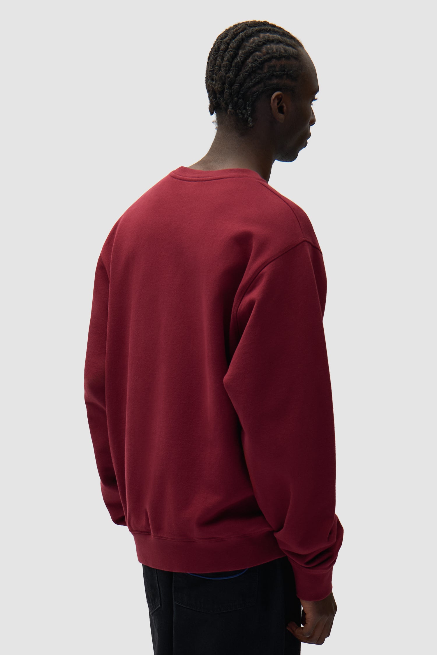 Pull à col rond multi-logos bordeaux porté par un mannequin, vue de dos à mi-corps