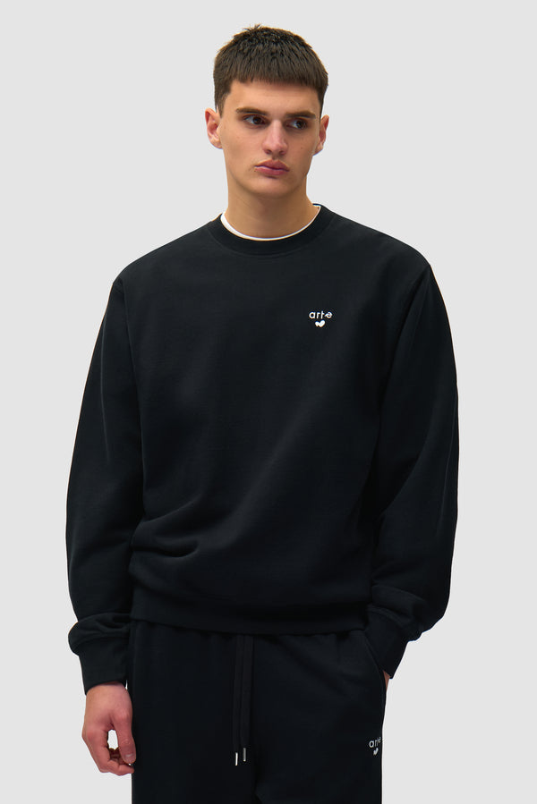 Heart Logo Crewneck in Black worn by a model, half-body front view