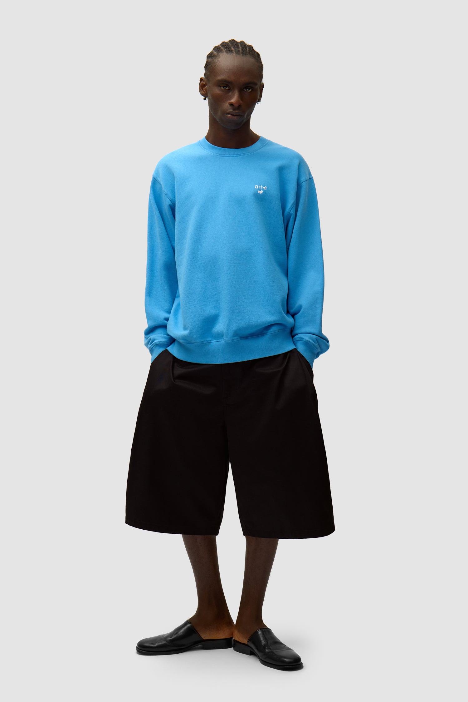 T-shirt à col rond avec logo en forme de cœur bleu porté par un mannequin, vue de face en pied