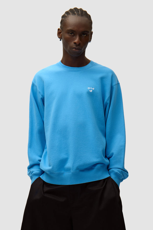Heart Logo Crewneck in Blue worn by a model, half-body front view