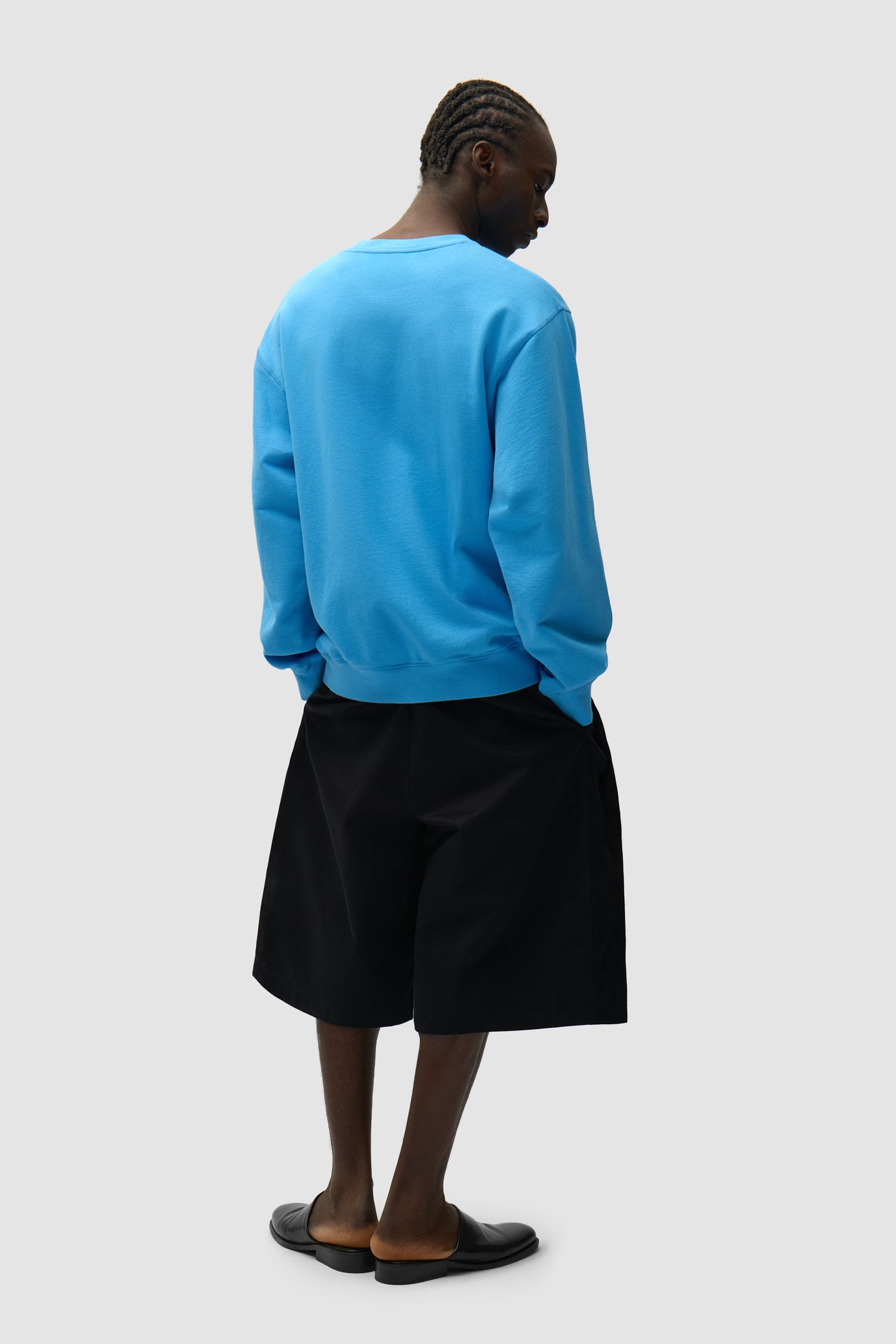 T-shirt à col rond avec logo en forme de cœur bleu porté par un mannequin, vue arrière en pied