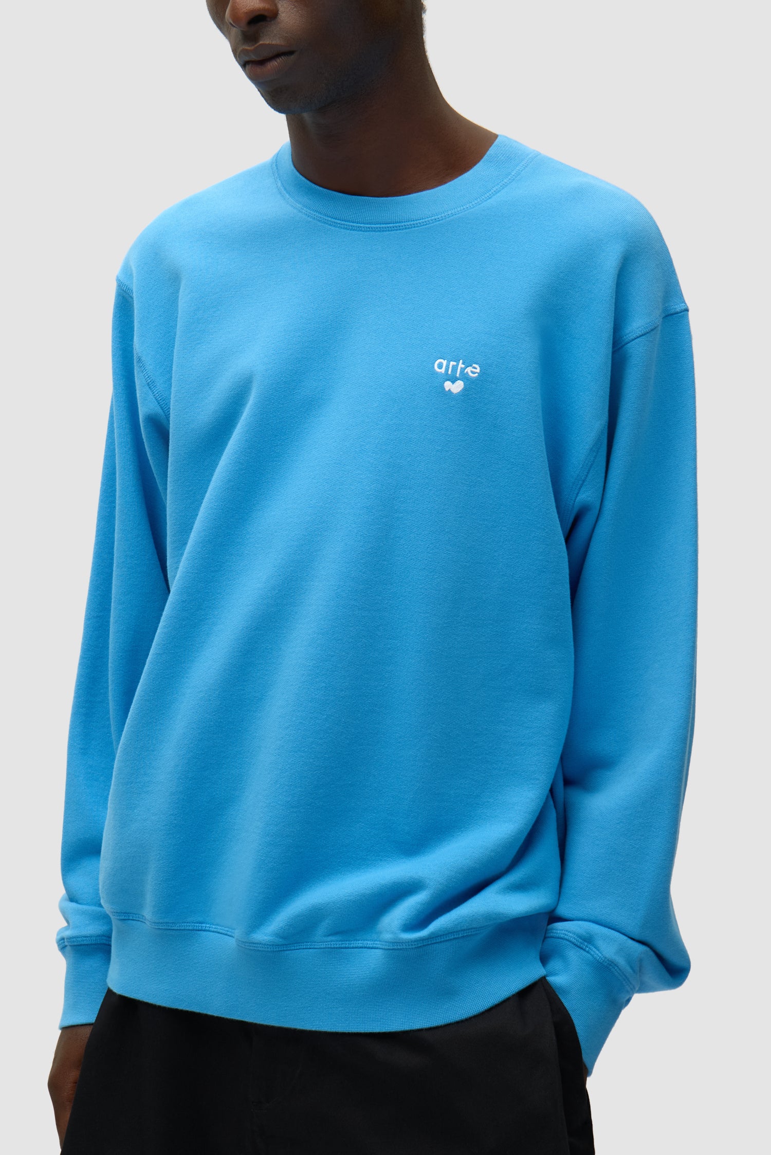 T-shirt à col rond avec logo en forme de cœur, couleur bleue, porté par un mannequin, vue de profil