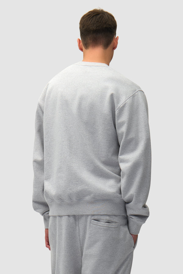 Heart Logo Crewneck in Grey worn by a model, half-body back view