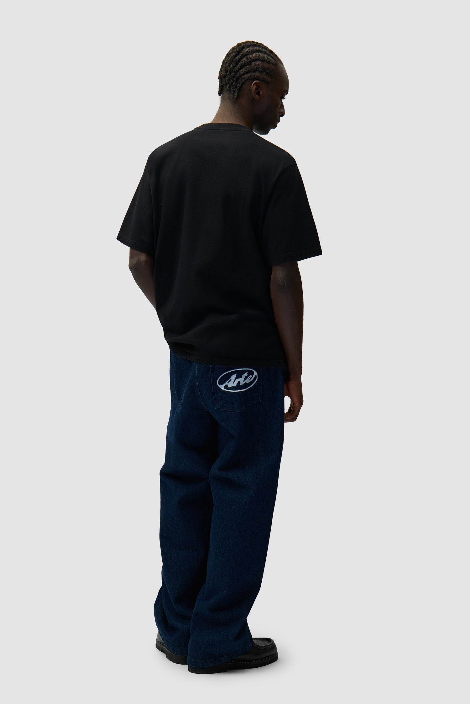 Circle Logo Pocket Pants in Raw Denim worn by a model, full-body back view