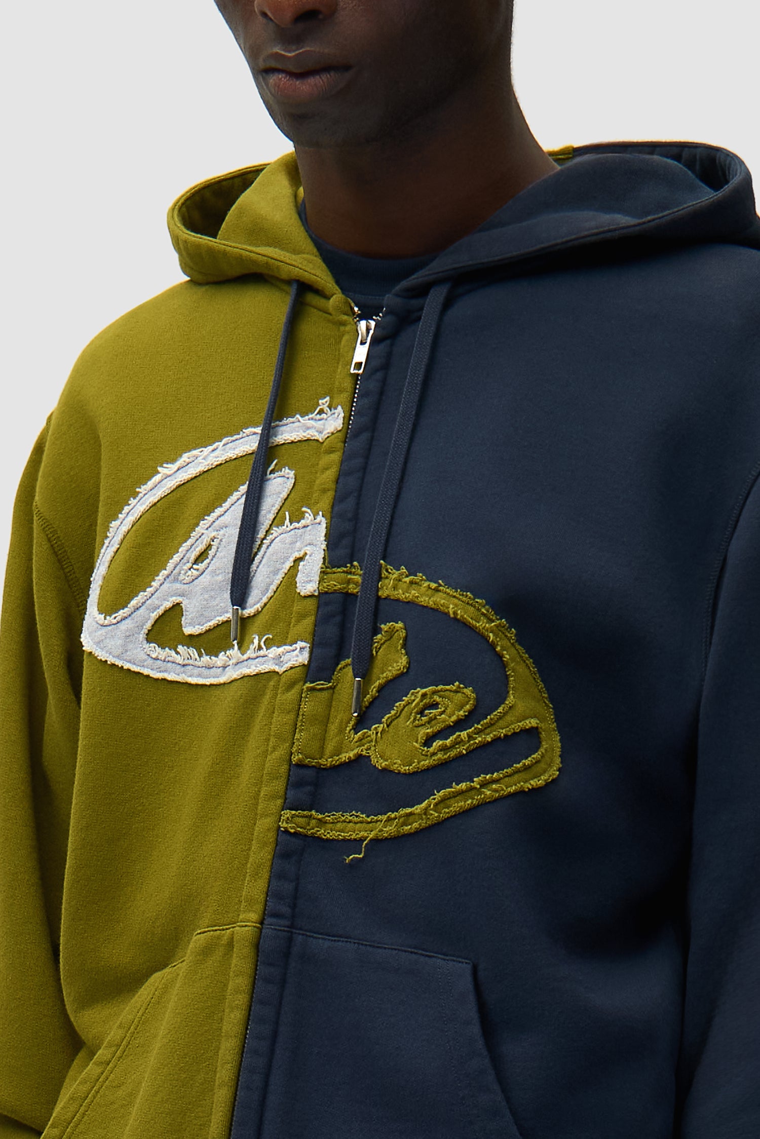 Detail view of Split Patch Zip Hoodie in Green/Navy, showing front logo