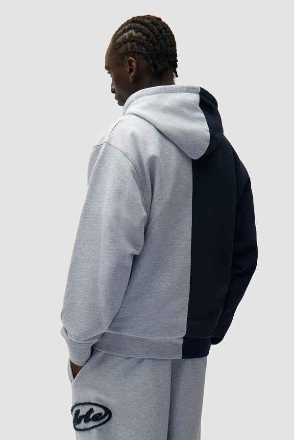 Split Patch Zip Hoodie in Grey/Navy worn by a model, half-body back view
