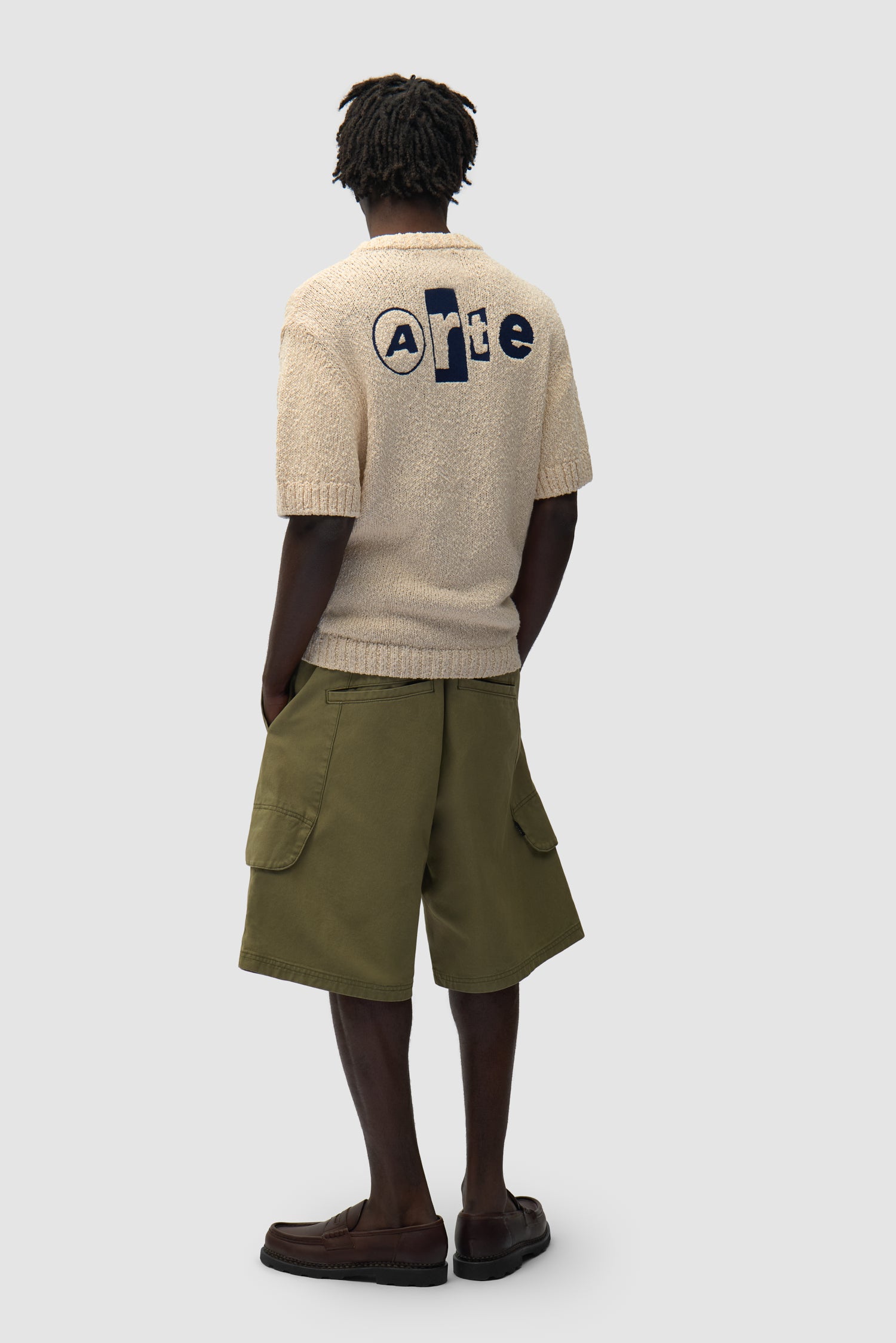 T-shirt en maille avec motif graphique dans le dos, couleur crème, porté par un mannequin, vue de profil en pied