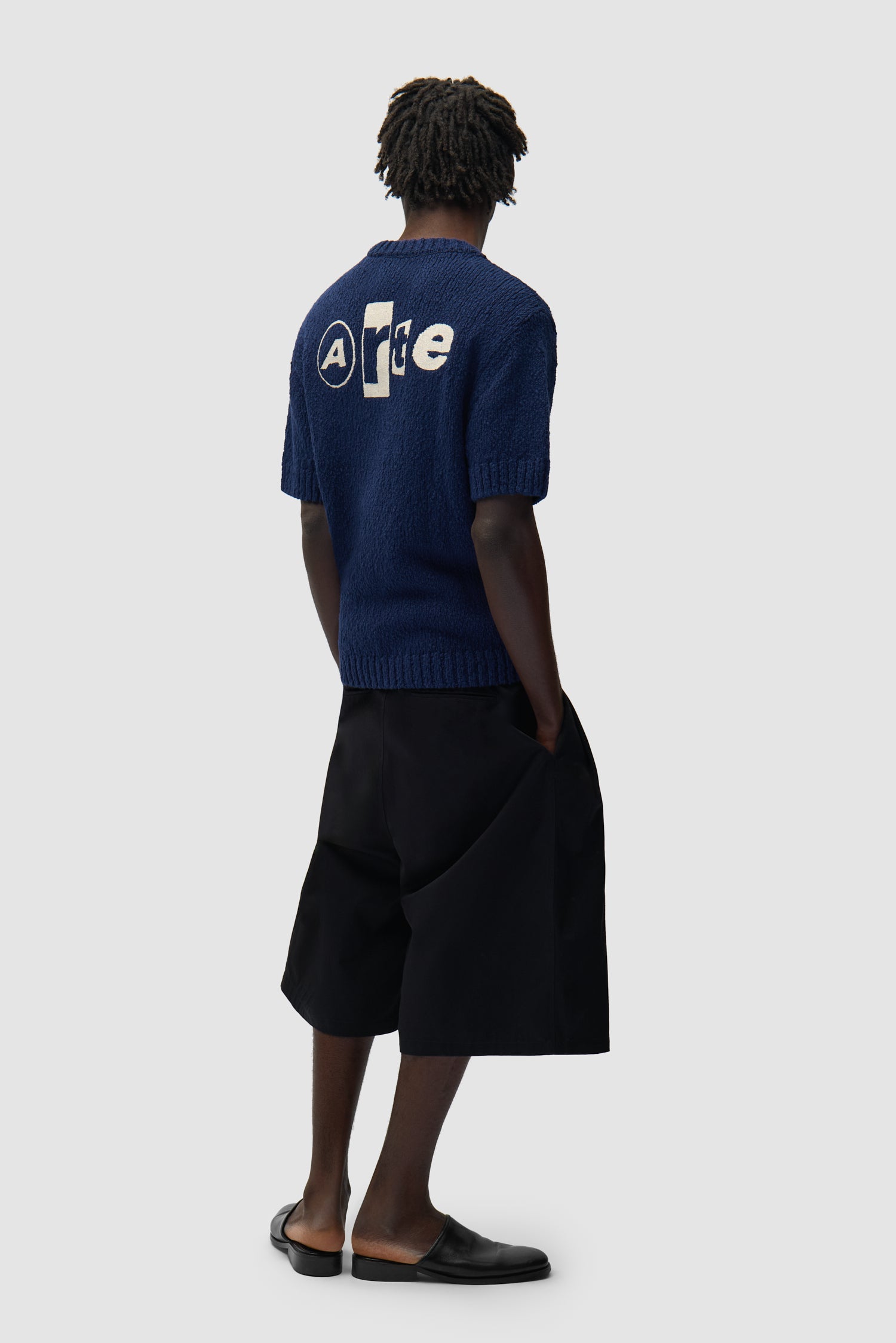 T-shirt en maille avec motif graphique au dos, couleur bleu marine, porté par un mannequin, vue de profil en pied