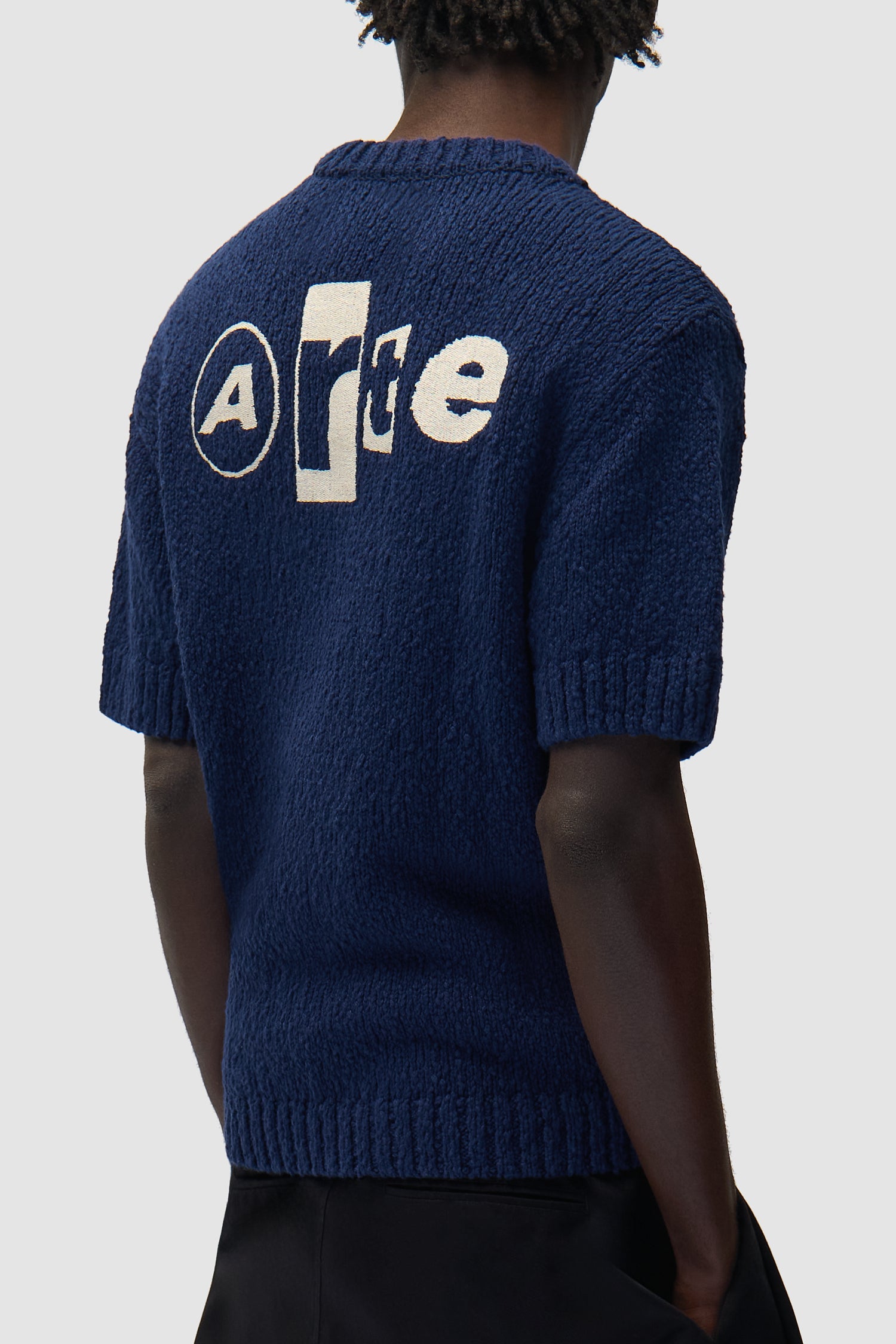 T-shirt en maille avec motif graphique au dos, couleur bleu marine, porté par un mannequin, vue de profil