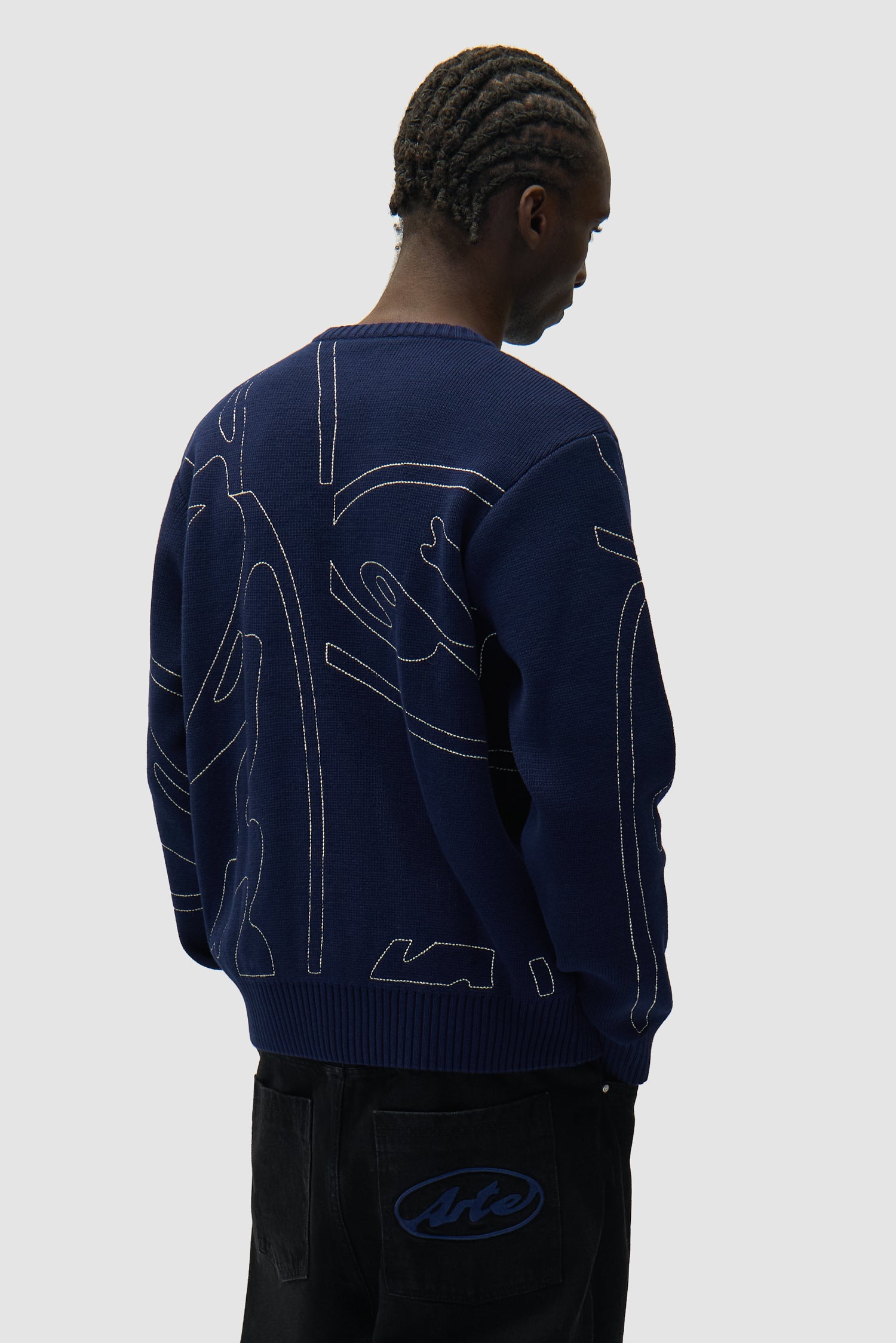 Allover Circle Logo Knit in Navy worn by a model, half-body back view