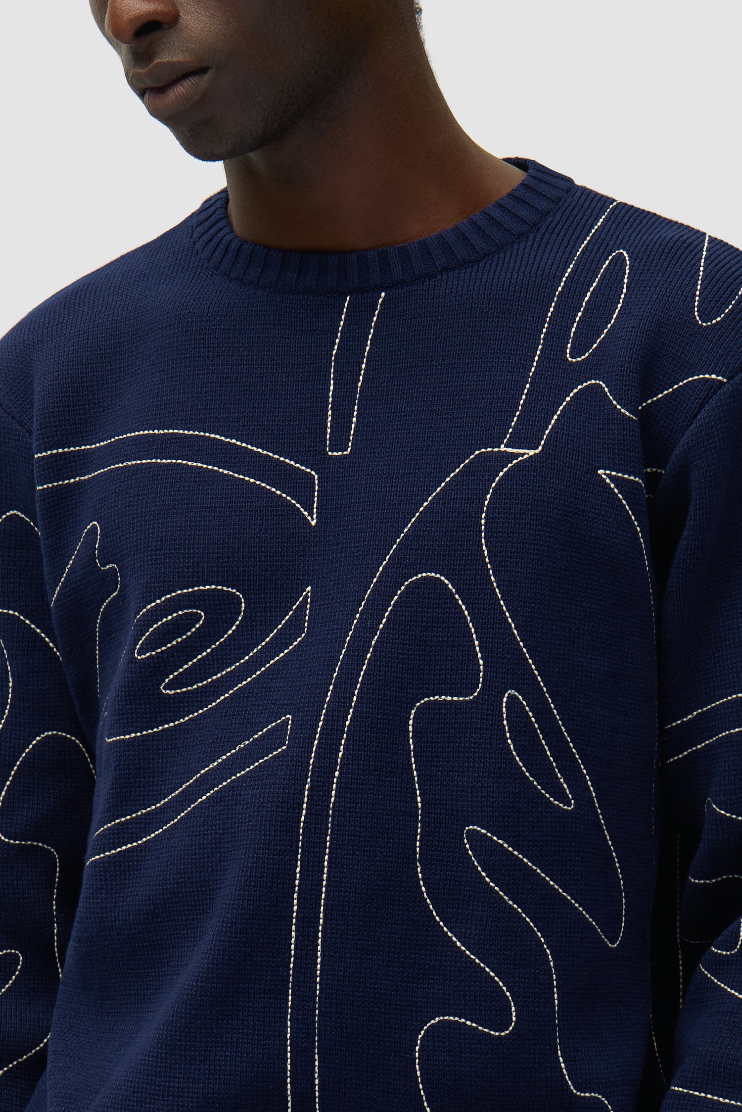 Detail view of Allover Circle Logo Knit in Navy, showing front design