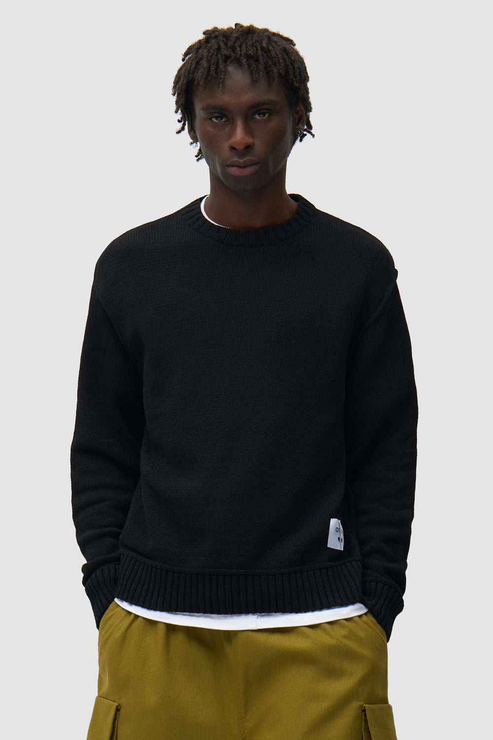 Étiquette réversible Tricot noir porté par un mannequin, vue de face en demi-corps