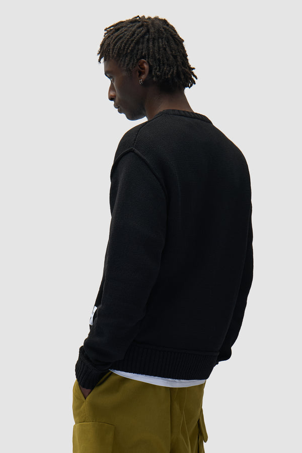 Reversible Label Knit in Black worn by a model, half-body back view