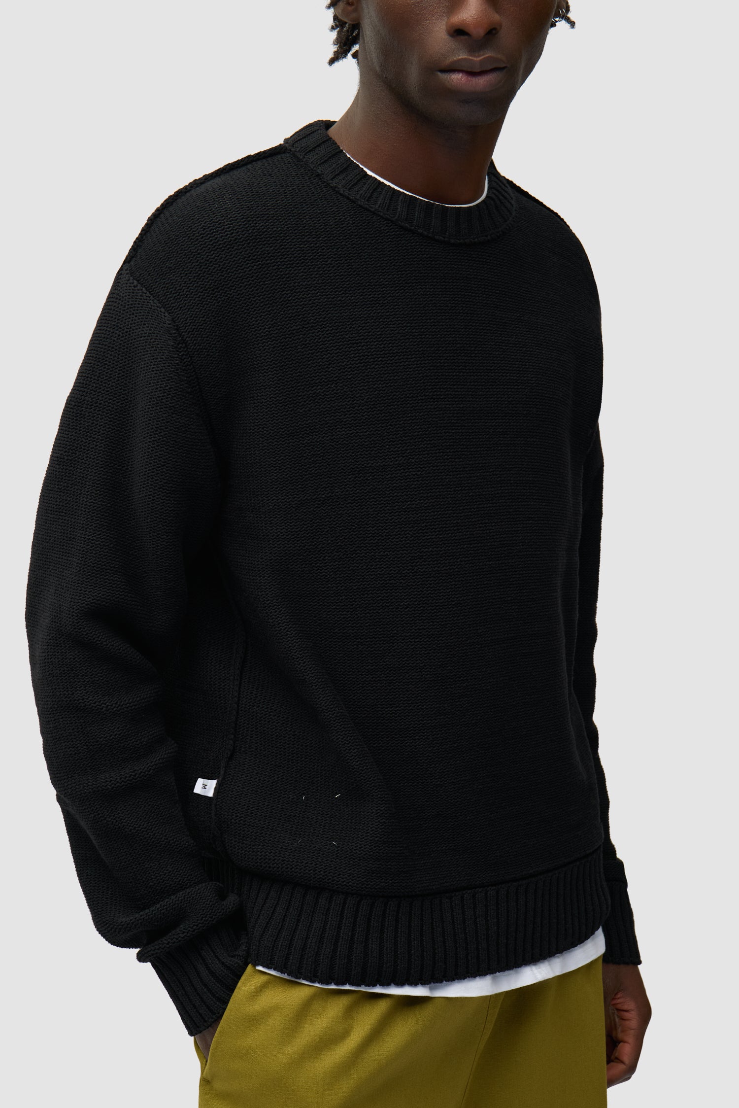 Étiquette réversible Tricot noir porté par un mannequin, vue détaillée du demi-corps