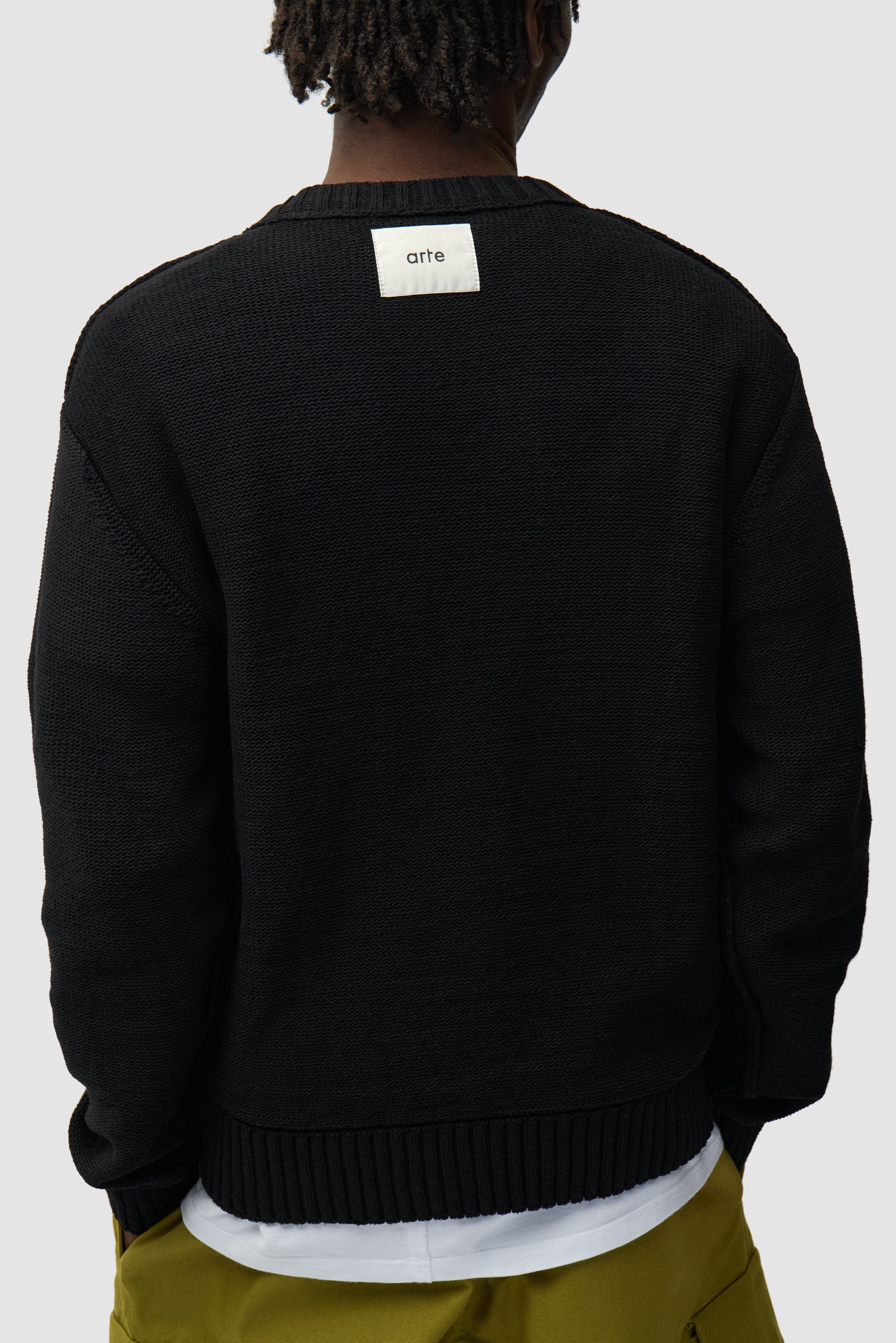 Étiquette réversible Tricot noir réversible porté par un mannequin, vue de dos à mi-corps