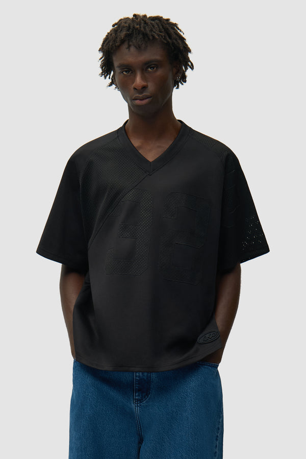 32 Jersey in Black worn by a model, half-body front view