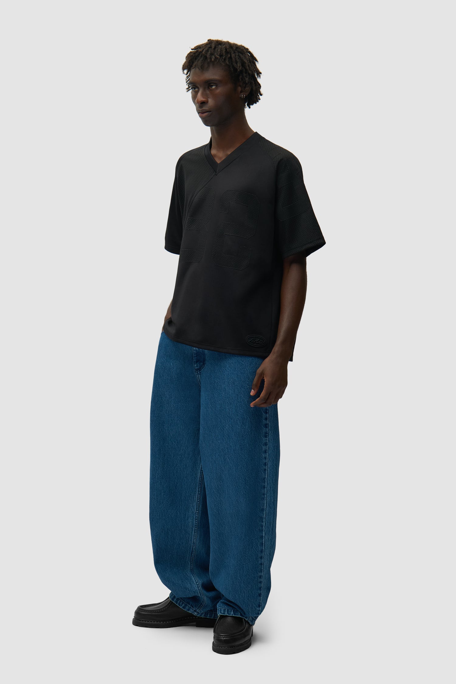 32 Jersey noir porté par un mannequin, vue de profil en pied