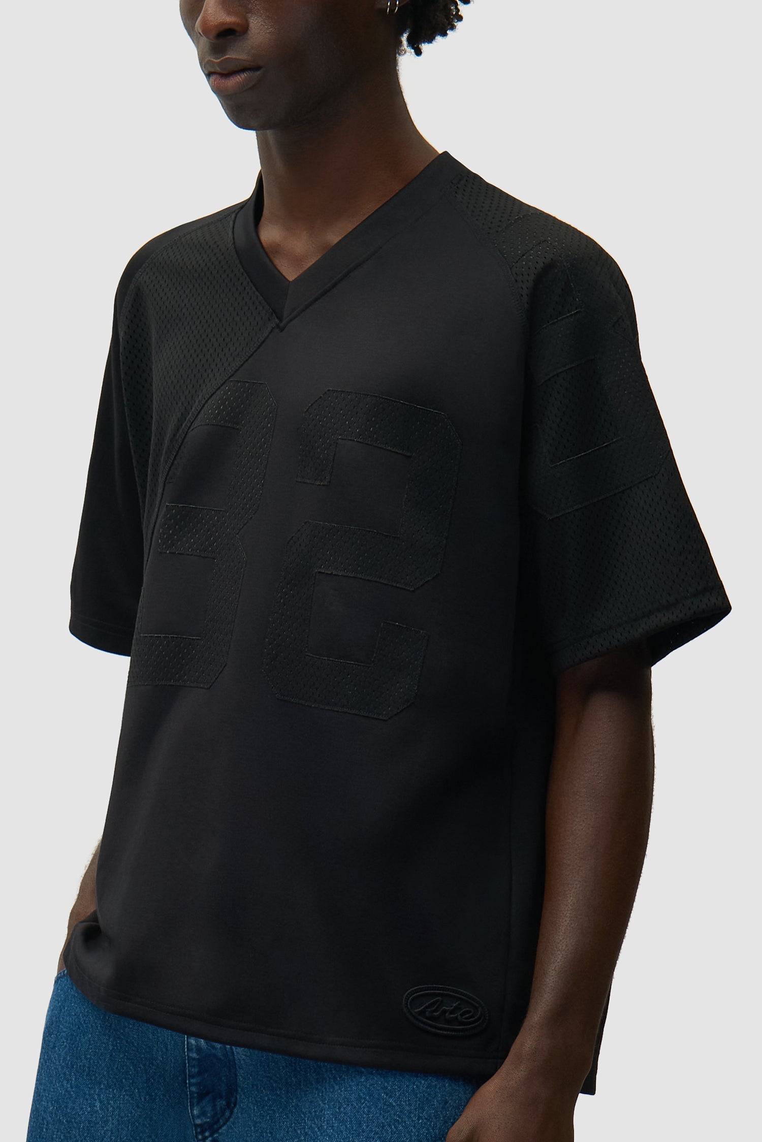 32 Jersey noir porté par un mannequin, vue de profil à mi-corps