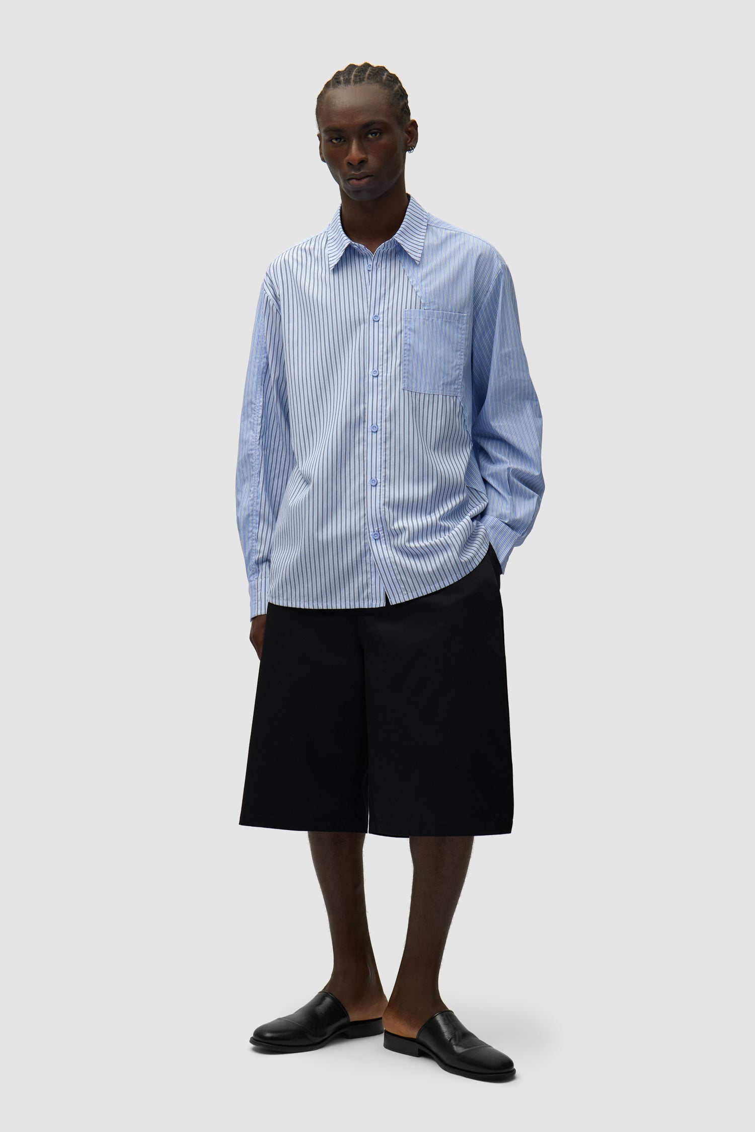 Chemise longue asymétrique à rayures portée par un mannequin, vue de face en pied