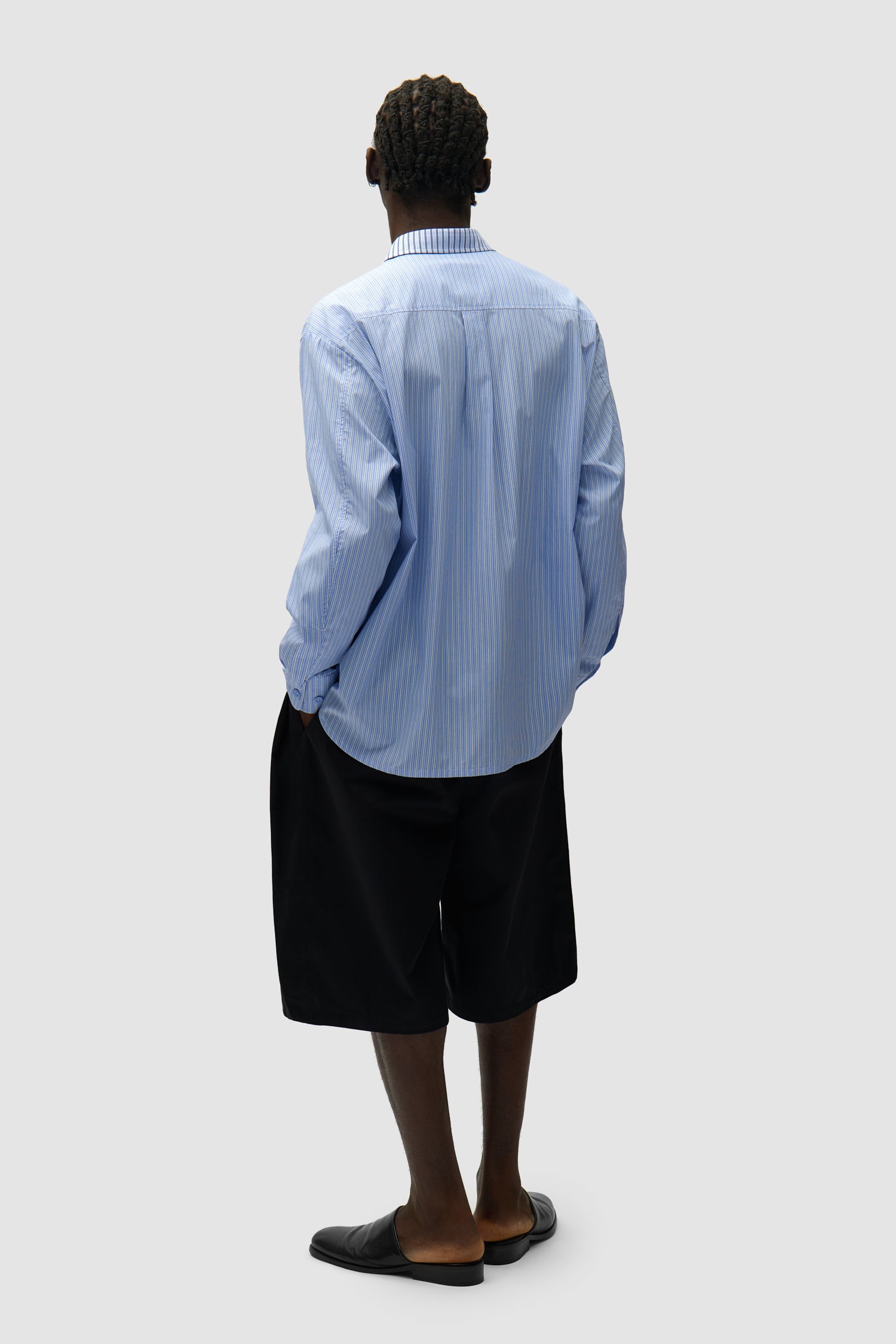 Chemise longue asymétrique à rayures portée par un mannequin, vue arrière en pied