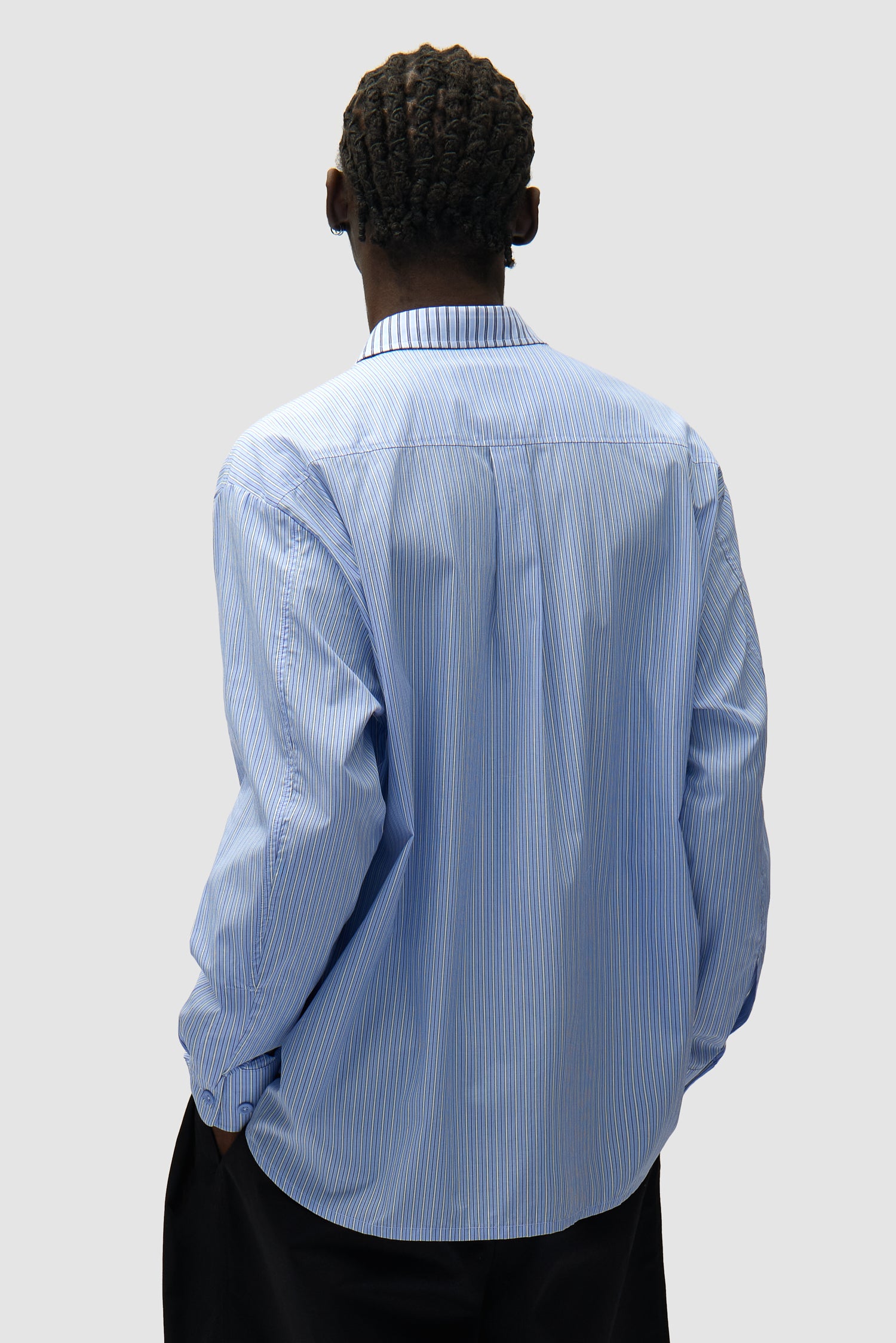 Chemise longue asymétrique à rayures portée par un mannequin, vue de dos en demi-corps