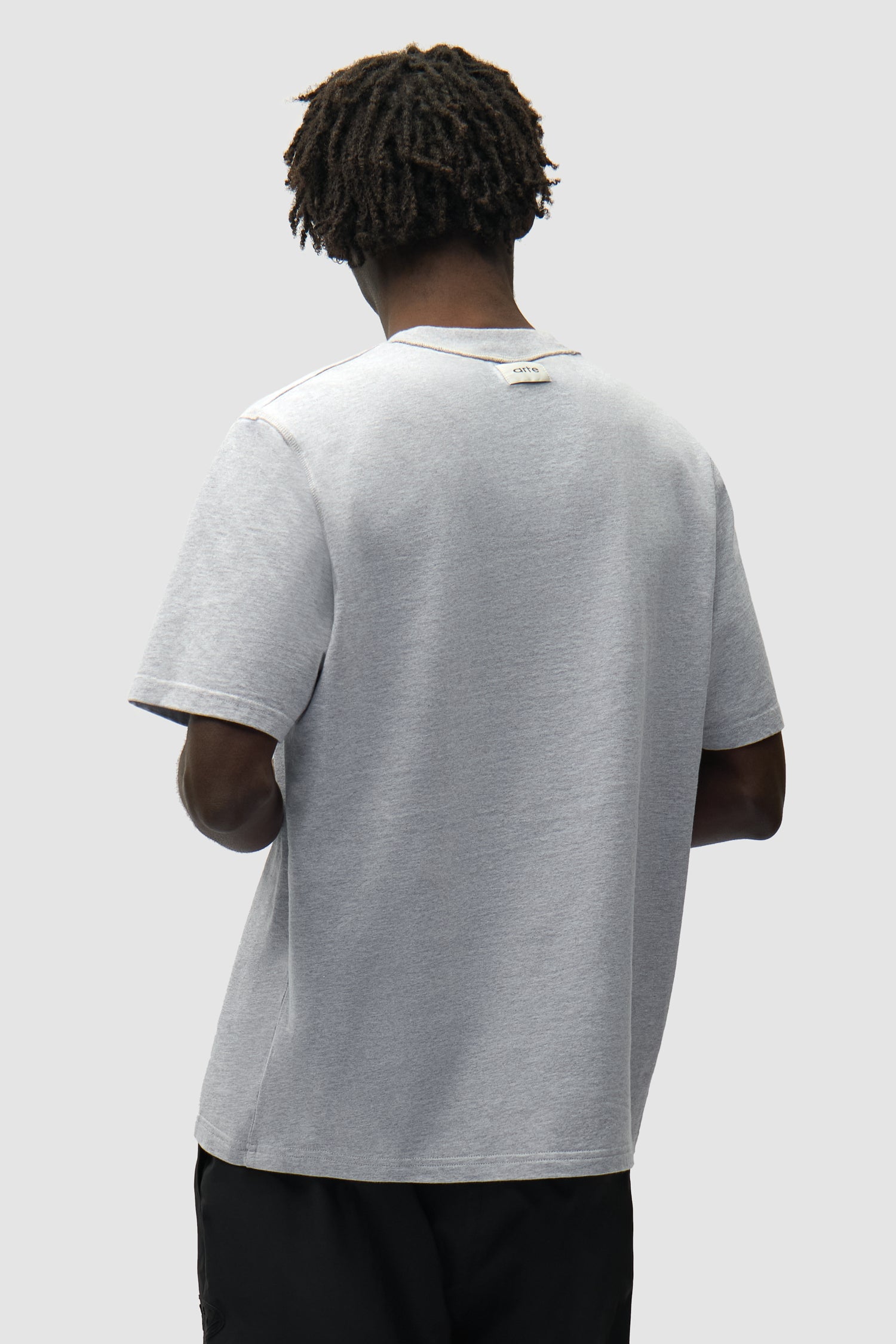 T-shirt réversible gris inversé porté par un mannequin, vue de dos à mi-corps